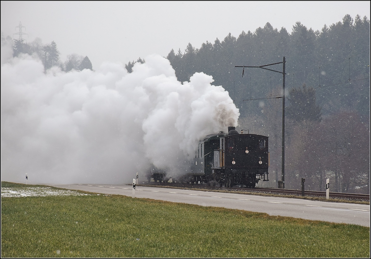 Dampflok Ed 3/4 Nr. 2 der Solothurn-Münster-Bahn bei Häusernmoos. Betreut wird die Lok durch den Verein historische Emmentalbahn. Mit im Gepäck hat sie zwei vierachsige Leichtstahlplattformwagen und einen K2. Februar 2018. 