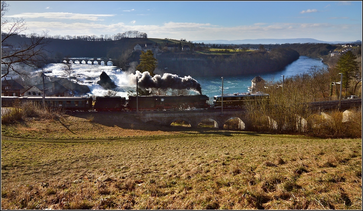 Das Gespann 01 1066 und  Ae 6/6 11407 passiert in Langsamfahrt den Rheinfall. Jestetten, März 2015.