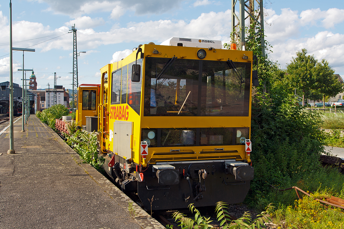 
Das Gleisarbeitsfahrzeug  99 80 9150 001-2 D-STRA der STRABAG Rail, ein Robel Bamowag 54.20, ist am 11.08.2014 beim Hauptbahnhof Wiesbaden angestellt. 

Der Bamowag 54.20 wurde 2010 von der ROBEL Bahnbaumaschinen GmbH in Freilassing unter der Fabriknummer 57.20-0003 gebaut. Das GAF hat in beiden Kabinen einen Fhrerstand, wobei Kabine mit dem TEREX Greifer sich auf einem Drehkranz befindet. 

Technische Daten (laut Anschriften): 
Spurweite: 1.435 mm 
Lnge ber Puffer: 14.400 mm 
Achsabstand: 9.000 mm 
Kleinster bef. Gleisradius: R 95 m 
Zul. Streckenklasse: C2/CM2 und hher 
Eigengewicht: 37.000 kg 
Nutzlast: 5 t Zul. 
Anhngelast: 100 t 
Hchstgeschwindigkeit: 100 km/h 
Zur Mitfahrt zugel. Personen: 5