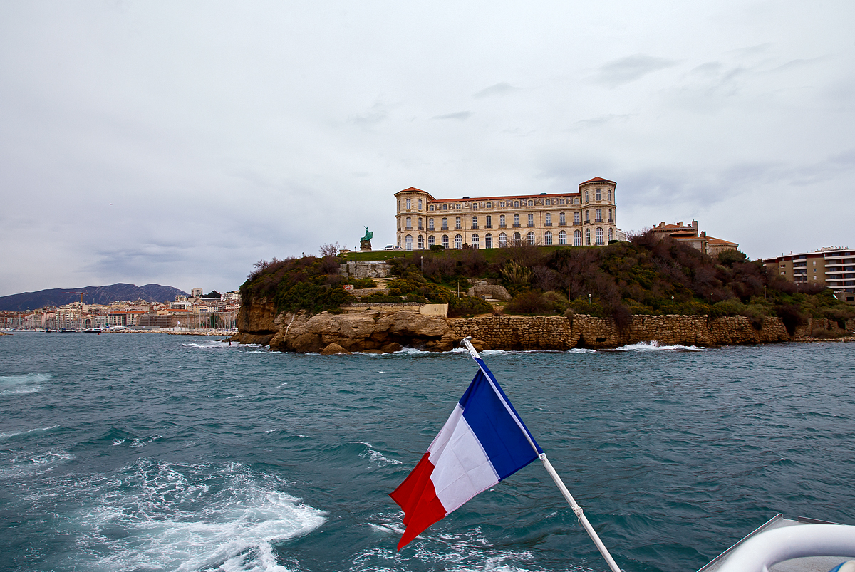 Das Palais du Pharo in Marseille am 25.03.2015 von der Seeseite.

Der Palast wurde ab 1858 von Napoleon III. (Geburtsnamen Charles-Louis-Napoléon Bonaparte) für seine Frau Eugénie de Montijo erbaut. Napoleon III. war von 1852 bis 1870 Kaiser der Franzosen, er war der Neffe von Napoleons I. (Napoleon Bonaparte).Napoleon der III. hatte übrigens 1867 die Annexion Luxemburgs geplant die aber ja bekanntlich scheiterte.

Das Palais liegt gegenüber dem Fort Saint-Jean mit Blick auf den Hafen und der Bucht von Marseille. Beim Sturz von Napoleon III. im Jahr 1870 war der Palast nach zwölf Jahre Bauzeit noch nicht fertiggestellt, so hat das Kaiserpaar dort nie gelebt.

Nach dem Sturz des Regimes griffen Gegner Napoleons III. Symbole des Imperiums an; insbesondere zerstörte die Menge napoleonischen Embleme und Ornamente, die die Fassade des Gebäudes schmückten.

Als der ehemalige Kaiser 1973 starb, reichte die Stadt Marseille Klage gegen die ehemalige Kaiserin ein. Dies führt zu einem Prozess, an dessen Ende Eugenie 1884 beschloss, das Schloss und seine Gärten der Stadt anzubieten, sofern sie für gemeinnützige Zwecke genutzt werden.
