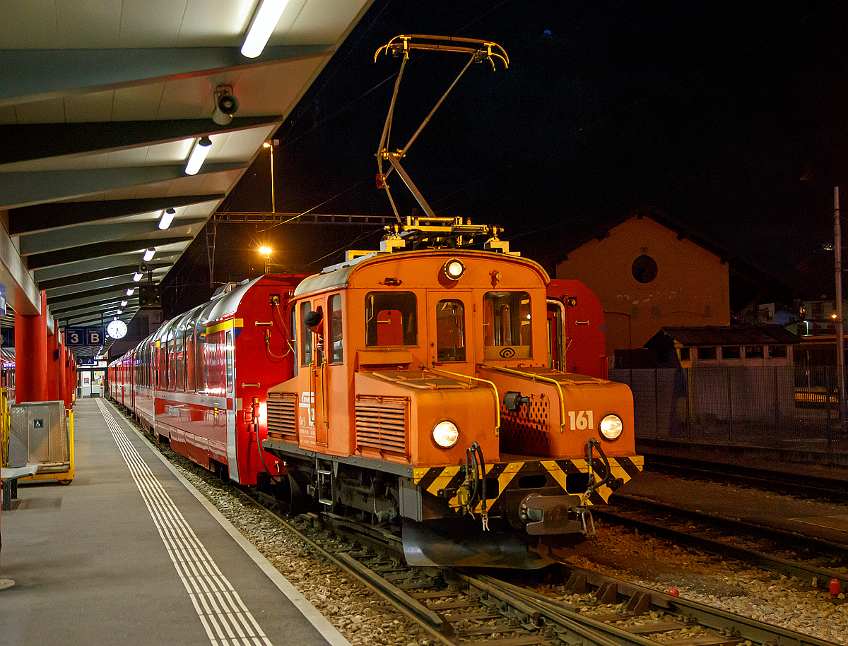 
Das RhB  Eselchen  161 bzw. der Rangiertraktor RhB Ge 2/2 161, ex BB Ge 2/2 61 rangiert am 18.02.2017 einige Wagen im RHB-Bahnhof Tirano. 

Der RHB-Bahnhof Tirano ist der Endbahnhof der Berninabahn und bedingt dadurch ein Kopfbahnhof. Bei den meist von Triebwagen geführten Züge werden dann die Personenwagen (teilweise auch Güterwagen) abgehangen und von der RhB Ge 2/2 auf ein anderes Gleis rangiert. Danach setzt der Triebwagen um und setzt sich für die Gegenrichtung wieder vor die Wagen.

Von der kleinen Elektrolokomotive Ge 2/2 wurden nur zwei Loks von diesem Typ für Berninabahn (BB) , heute der Rhätischen Bahn (RhB), gebaut, ursprünglich die BB 61 und BB 62, seit 1961 mit den Nummern RhB 161 und 162.

Beide Gleichstromloks wurden 1911 von der Berninabahn (BB) für Vorspanndienste beschafft, sie wurden von SIG und Alioth gebaut. Die damals noch braun lackierten Maschinen erhielten die Nummern Ge 2/2 61 und 62 und waren noch mit Lyra-Stromabnehmern bestückt. Nach der Übernahme der BB durch die RhB im Jahre 1942 wurden sie verschiedentlich modernisiert; sie tragen heute einen Einholmstromabnehmer und sind meistens als Rangierloks in Tirano und Poschiavo tätig.

Sie werden wegen ihrer Form auch  Mini-Krokodile  oder wegen ihres Aufgabenbereichs  Eselchen  genannt.  Zwischen den Vorbauten ist ein Gang, so dass ein Übergang zum Zug möglich war. Die Benutzung ungeschützter Übergänge ist aber inzwischen selbst dem Personal untersagt, so wurden folgerichtig an den beiden Loks die Übergangsbleche entfernt. Die Loks sind die zweitältesten im Dienst befindlichen Lok der RHB.

Technische Daten der Ge 2/2
Betriebsnummern: 161 und 162 (ex 61 und 62)
Hersteller: SIG, Alioth
Baujahr: 1911
Anzahl Fahrzeuge: 2
Spurweite: 1.000 mm
Achsanordnung: B
Länge über Puffer: 7.740 mm
Breite: 2.500 mm
Achsabstand: 
Triebraddurchmesser (neu): 975 mm
Dienstgewicht:  18.0 t
Höchstgeschwindigkeit: 45 km/h
Stundenleistung: 250 kW (340 PS)
Anfahrzugkraft: 37,6 kN
Stundenzugkraft: 27,5 kN bei 27 km/h
Motorentyp:  Gleichstrom Reihenschluss
Fahrleitungsspannung: 1 kV DC (Gleichstrom) / 750 V DC vor 1935 