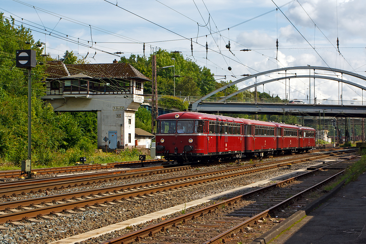 
Das Südwestfälisches Eisenbahnmuseum in Siegen hatte das bekannte Lokschuppenfest (16./17. Aug. 2014), anlässlich dieses fanden Schienenbus Pendelfahrten zwischen Siegen und Kreuztal statt. Hier passiert am 16.08.2014 die vierteilige Uerdinger-Schienenbus-Garnitur vom Förderverein Schienenbus e.V. aus Menden (Sauerland) das Fahrdienstleiter Stellwerk Kreuztal (Kf) und erreicht gleich den Bahnhof. 

Die Garnitur bestand aus (von vorne nach hinten): 

Motorwagen 9580 0796 690-5 D-EVG, ex DB 796 690-6, ex DB 798 690-4, ex DB VT 98 9690, ein echter  Uerdinger  (1960 bei der Waggonfabrik Uerdingen gebaut). Zuletzt wurde er vom Bw Siegen aus eingesetzt, wo er am 11. November 1995 ausgemustert wurde.

Beiwagen 9580 0996 299-3 D-EVG, ex DB 996 299-4, ex DB 998 299-2, ex DB VB 98 2299, von Rathgeber 1961 gebaut und bis 31.12.1981 im BW Betzdorf(Sieg) geheimatet. Ausgemustert wurde er  1996 im Bw Tübingen.


Beiwagen 9580 0996 309-0 D-EVG, ex DB 996 309-1, ex DB 998 309-9, ex DB VB 98 2309, von Rathgeber 1960 gebaut und am 30.06.1994 beim Bw Gießen ausgemustert.

Motorwagen 9580 0796 802-6 D-EVG, ex DB 796 802-7, ex DB 798 802-5, ex DB VT 98 9690, ein Lizenzbau 1961 von MAN. Zuletzt wurde er vom Bw Siegen aus eingesetzt, wo er am 30. November 1995 ausgemustert wurde.

Die beiden Motorwagen werden jeweils von zwei Diesel-Unterflurmotoren des Typs Büssing U 10 der Büssing AG, mit einer Leistung von  je 110 kW (150 PS) angetrieben. Die Leistungsübertagung erfolgt über ZF Sechs-Gang-Getriebe mechanisch auf die Achsen.

Die einzelnen Wagen haben im Laufe ihres Betriebslebens zahllose unterschiedliche Nebenbahnen befahren haben, von denen heute teilweise allenfalls noch ein Bahndamm auszumachen ist.
Aber alle waren mal hier in der Region beheimatet, was heute hier die LINT sind das waren früher die Uerdinger.
