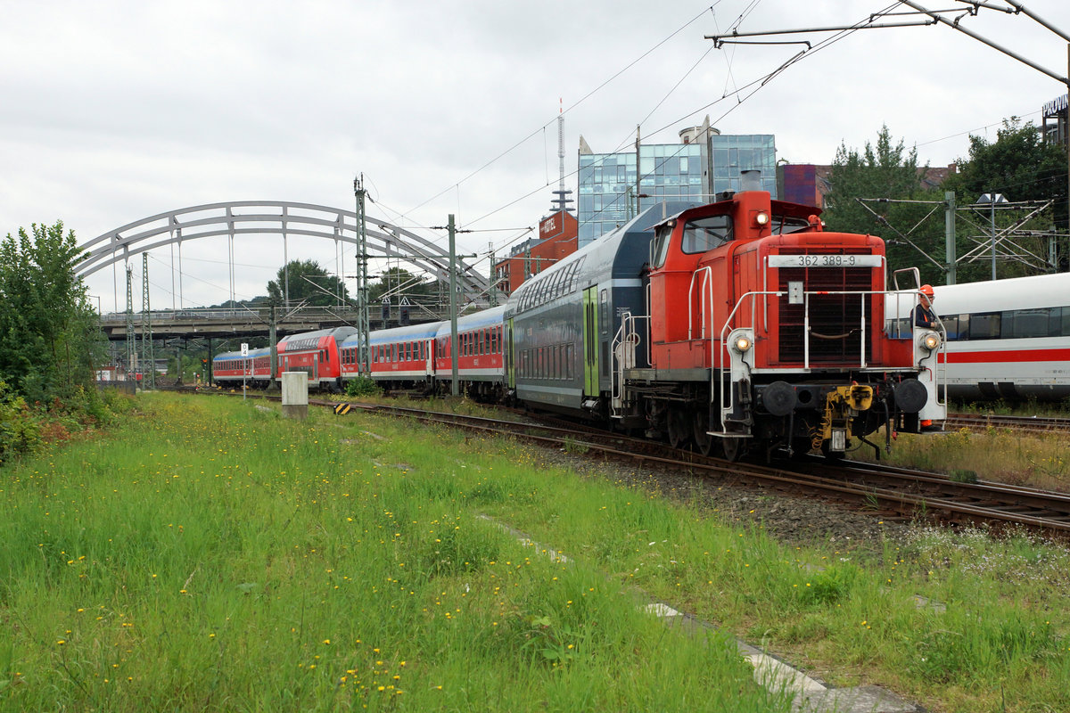 DB: Rangierfahrt mit der 362 389-9 am 11. August 2016 in Kiel. Besonders zu beachten sind der Doppelstockwagen mit dem neuen grnen Anstrich sowie die ehemaligen Wagen vom DB Fernverkehr mit dem blauen Streifen. Diese Wagen gelangen noch im Regionalverkehr Kiel-Neumnster zum Einsatz.
Foto: Walter Ruetsch