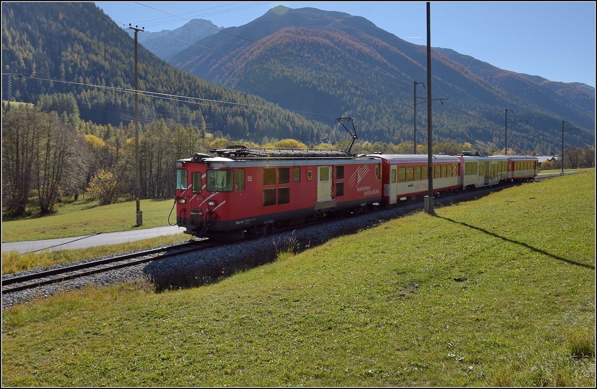 Deh 4/4 55 der Matterhorn-Gotthard-Bahn zieht einen Regionalzug das Wallis hinauf Richtung Andermatt. Münster, Oktober 2017.