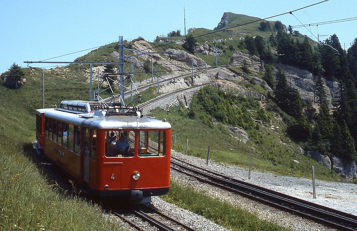 Der 1938 gebaute Bhe 2/4 4 der Vitznau-Rigi-Bahn ist im Juli 1983 unterwegs zur Bergstation Rigi Kulm. Das andere Streckengleis gehört zur Arth-Rigi-Bahn, trotz recht dichtem Verkehrs an diesem Tag und geduldigen Wartens ist mir nicht gelungen, Züge beider Bahnen auf ein Bild zu bekommen.