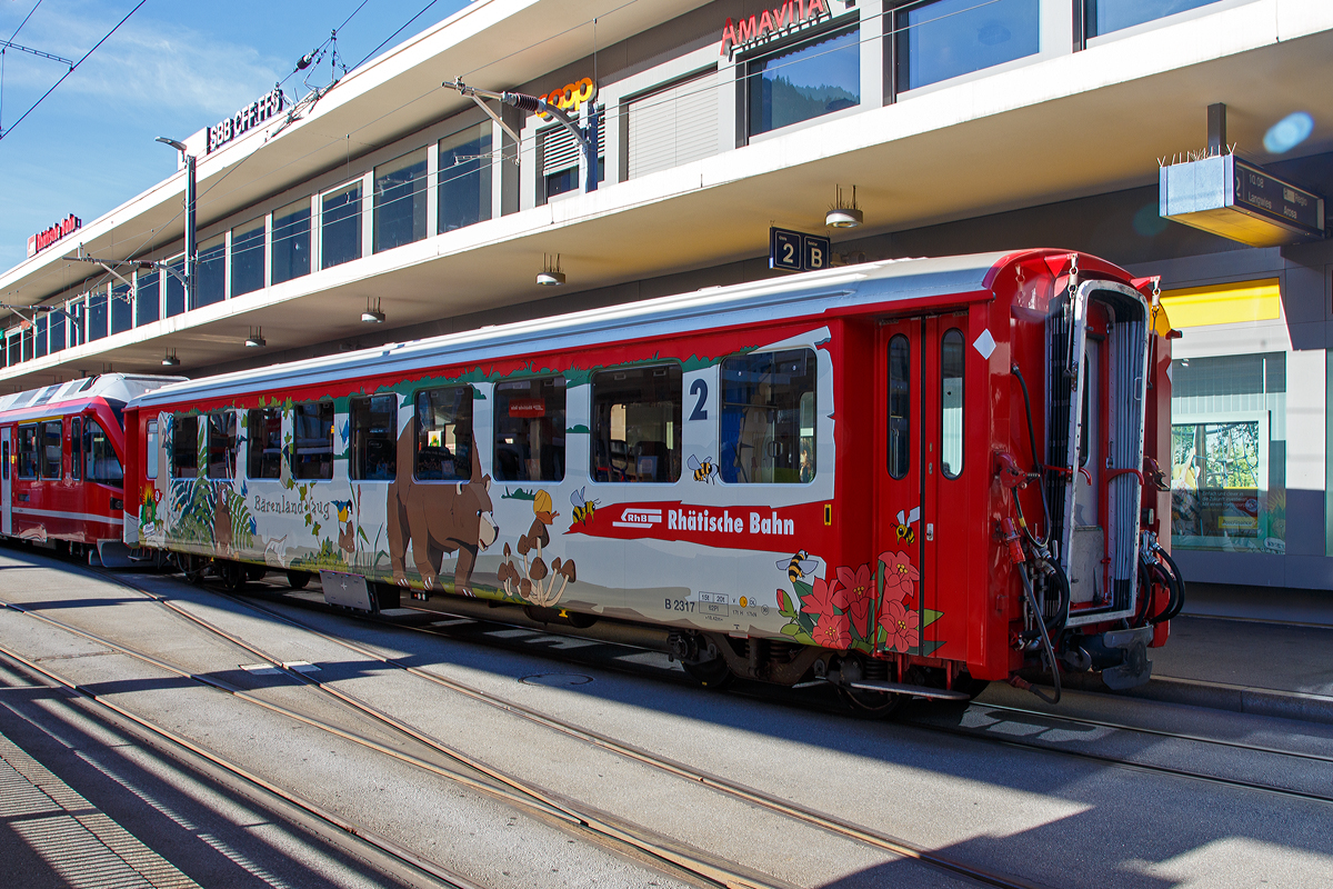 Der 4-achsige RhB Einheitswagen I (EW I) - B 2317  Brenland Arosa , ein 2. Klasse Personenwagen am 01.11.2019 in Chur (Bahnhofsvorplatz).

Im August 2018 wurde bei Arosa das Brenland erffnet. Fr diesen Anlass hat die RhB die Einheitswagen EW I B 2315 -2319 zu Brenlandwagen innen und auen umgestaltet. Mit der Bahn anreisende Besucher knnen sich bereits whrend der Bahnfahrt zum Beispiel mit Bchern einstimmen. 

Mit mehr als 100 Fahrzeugen bilden die als Einheitswagen I bezeichneten Personenwagen bis heute die grte Serie im Rollmaterialbestand der RhB. Das Fahrzeugkonzept wurde Anfang der sechziger Jahre in enger Zusammenarbeit zwischen Industrie und RhB entwickelt. Als Neuheit galten damals die Einstiegsbereiche mit WC und Stauraum fr sperriges Gepck an den Wagenbergngen. Folglich weicht das Konzept deutlich von den Mitteleinstiegswagen aus den vierziger Jahren ab.

Die ersten von FFA und SIG gebauten Einheitswagen I wurden Ende 1963 in Betrieb genommen. In einem Zeitraum von etwa zehn Jahren wuchs der Bestand an EW I kontinuierlich. Neben den 18,42 m langen Wagen, die hauptschlich auf dem Stammnetz eingesetzt werden, kamen auch Sonderbauformen mit Aluminiumwagenkasten hinzu. Zu diesen zhlen die auf 14,19 m verkrzten Fahrzeuge fr den Einsatz auf der Berninabahn.

TECHNISCHE DATEN (B 2315-2319):
Hersteller Wagenkasten: FFA
Hersteller Drehgestelle:  SWP
Inbetriebsetzung: 1969
Betriebsnummern: B 2315-2319
Anzahl Fahrzeuge: 5
Spurweite: 1.000 mm
Lnge ber Kupplung: 18.420 mm
Breite: 2.650 mm
Achsabstand im Drehgestell: 1.800 mm
Drehzapfenabstand: 12.830 mm
Gewicht: 13.000 kg
Sitzpltze: 62
zul. Hchstgeschwindigkeit: 90 km/h
Lauffhig: Chur-Arosa, StN (Stammnetz) / MGB (Matterhorn Gotthard Bahn) 
Auf der BB (Berniabahn) wre es mglich, aber nur bis Alp Grm. Denn dahinter werden die Gleisradien zu eng. Fr die BB wurden verkrzte Einheitswagen beschafft.