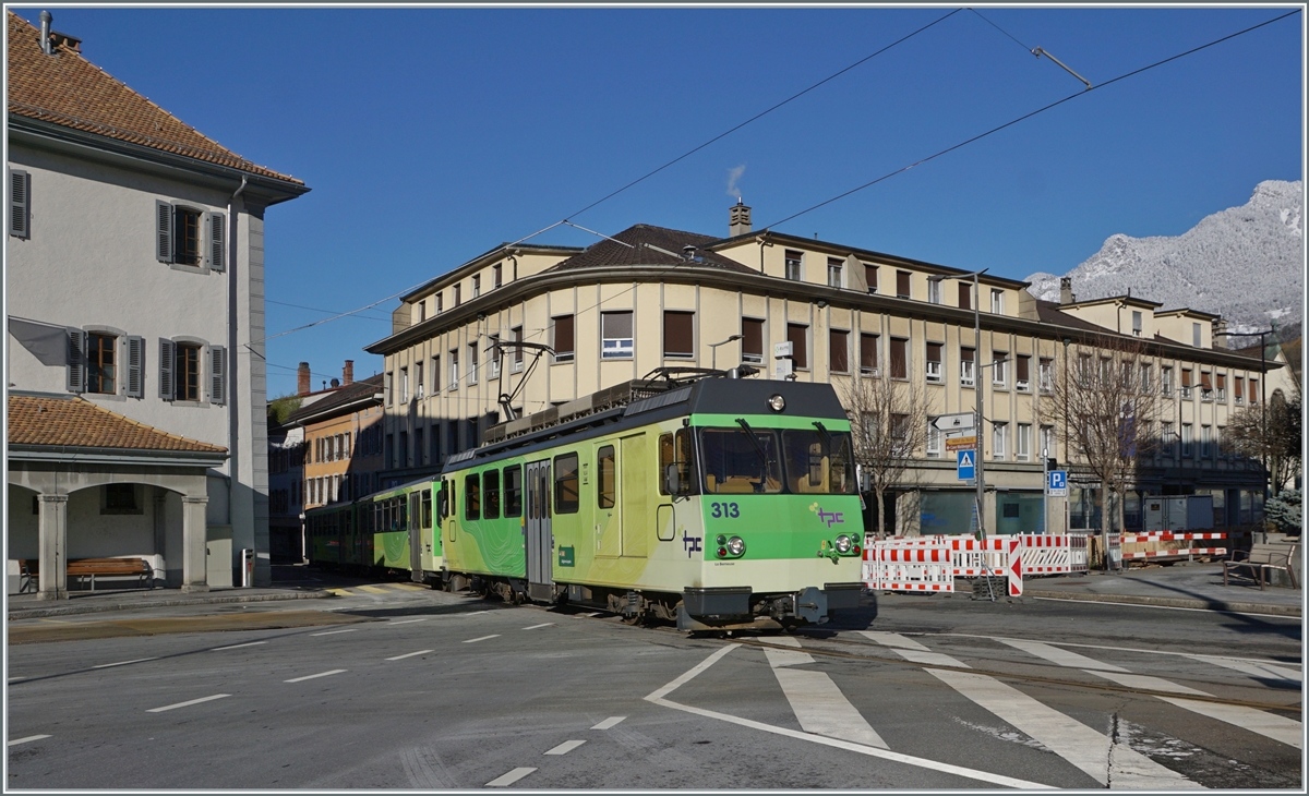 Der A-L BDeh 4/4 313 verlässt mit seinem Zug die Altstadt von Aigle. Der Zug ist von Aigles nach Leysin unterwegs und erreicht unmittelbar nach der Überquerung der Kreuzung die Haltestelle Aigle-Place-du Marché. Wie auf dem Bild rechts oben zu erkennen ist, hat es in den Bergen geschneit, weshalb bei diesem schönen Sonntagswetter der Zug neben dem BDe 4/4 313 zwei Wagen mitführt.

3. Dezember 2023