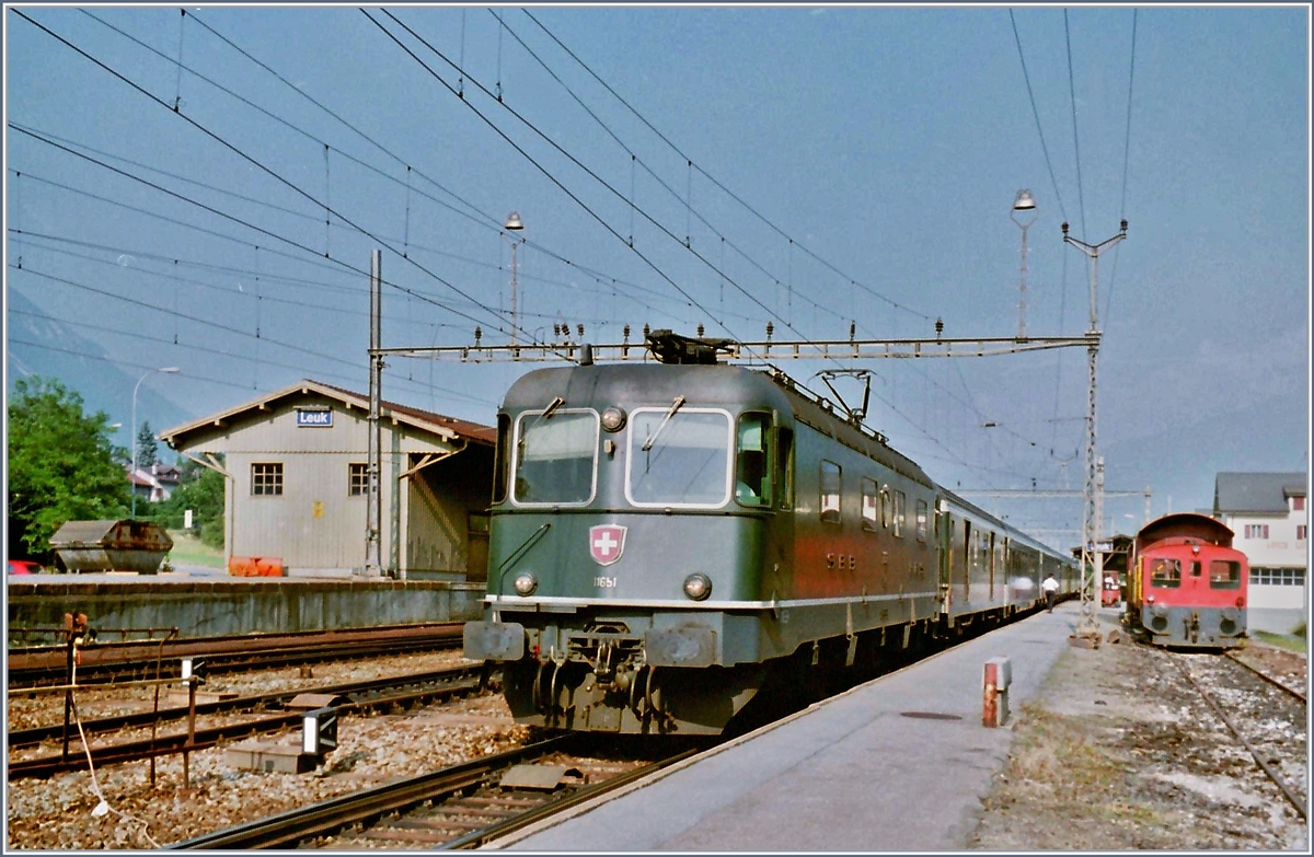 Der  alte  Bahnhof von Leuk lag gut hundert Meter südlicher als der neue und die Strecke Richtung Sion war bis Salgesch nur einspurig. Das Bild zeigt die Re 6/6 11651 mit einen IR Richtung Brig beim Halt im alten Bahnhof von Leuk. 

Im Juli 1995