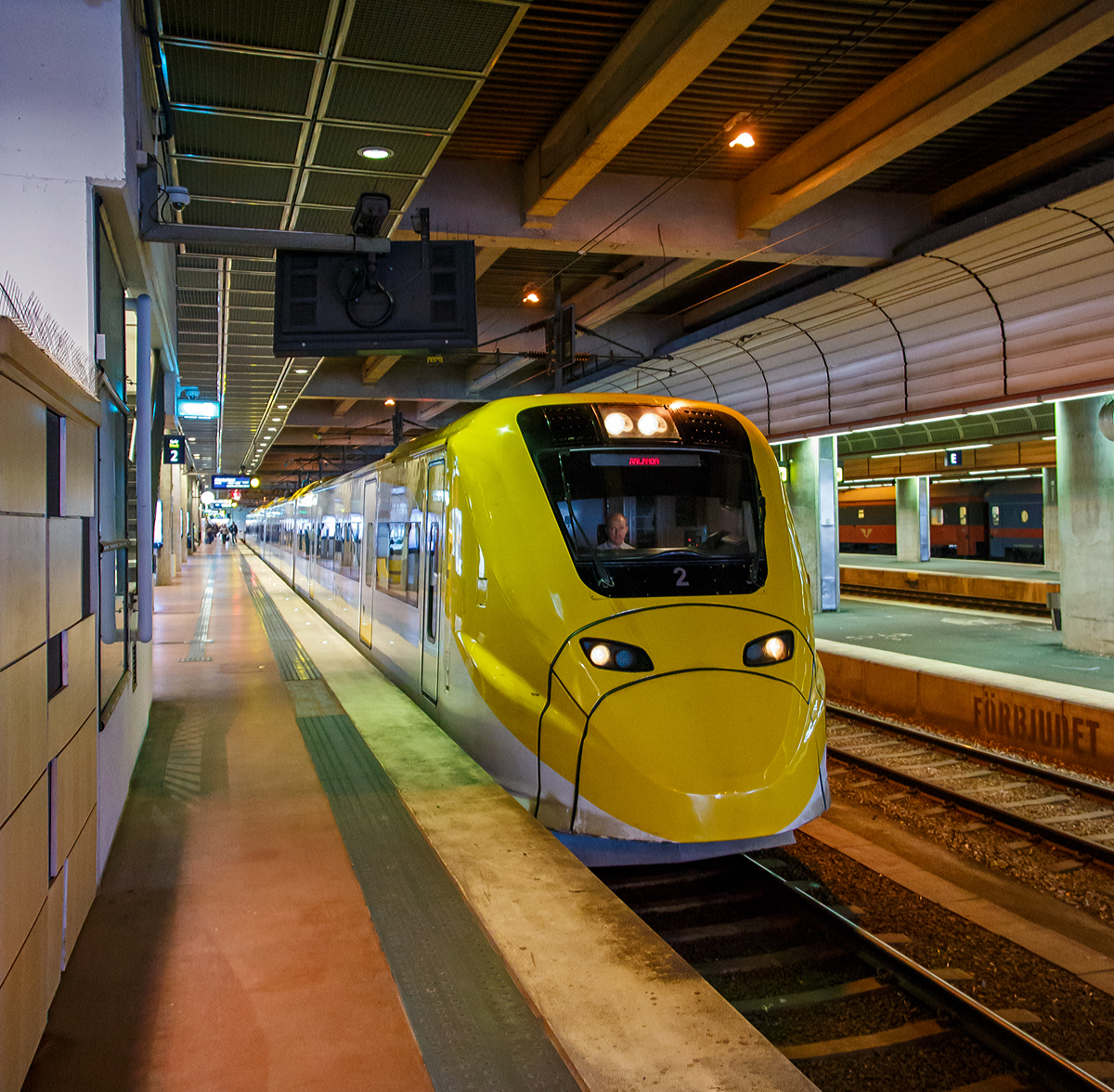 Der Arlanda Express Triebzug 2, ein Alstom Coradia X3, steht am 21.03.2019 auf Gleis 1 in Stockholm Central zur Abfahrt nach dem Flughafen Stockholm/Arlanda bereit.

Der vierteilige, normalspurige elektrische Triebwagenzug vom Typ X3 wird von der schwedischen Gesellschaft Arlanda Express fr den direkten Verkehr zwischen Stockholm C und Flughafen Stockholm/Arlanda verwendet.

Von Alstom wurden sieben dieser klimatisierten Zge in Birmingham gebaut und 1998/99 geliefert. Der X3 gehrt zur Obergruppe der Coradia-Triebwagen und kann Geschwindigkeiten bis 205 km/h erreichen. Die Zge sind wei und gelb lackiert. Die Triebwagen nutzen das gleiche Stromsystem, wie es im gesamten schwedischen Eisenbahnnetz vorhanden ist.

TECHNISCHE DATEN:
Spurweite:  1435 mm (Normalspur)
Achsformel: Bo'Bo'+2'2'+'2'2+Bo'Bo'
Lnge ber Kupplung: 93.084 mm
Dienstgewicht: 187 t
Hchstgeschwindigkeit: 200 km/h
Leistung: 2.240 kW
Stromsystem: 15 kV 16,7 Hz ~
Sitzpltze:  228

Arlanda Express ist eine schwedische Bahnverbindung, die mit dem 200 km/h schnellen Elektrotriebzug X3 seit 1999 den Stockholmer Hauptbahnhof mit dem Flughafen Stockholm/Arlanda verbindet. Die Zge bewltigen die Strecke in 20 Minuten. Am Flughafen bedienen sie die Stationen Arlanda Sdra und Arlanda Norra. Die Zge verkehren bis auf wenige Ausnahmen in den Tagesrandzeiten alle 15 Minuten, im Berufsverkehr etwa alle zehn Minuten.

In Arlanda und im Hauptbahnhof von Stockholm am Gleis 1 und 2 haben die Zge gesonderte Bahnsteige. Dort ist ein direkter stufenloser bergang vom Zug zum Bahnsteig mglich. Jeder Wagen verfgt ber zwei Tren und an jeder Tr sind Gepckablagen vorhanden. Der gesamte Zug besitzt 190 Sitzpltze. In einem der Wagen sind gesonderte Pltze fr Rollstuhlfahrer sowie ein WC vorhanden.