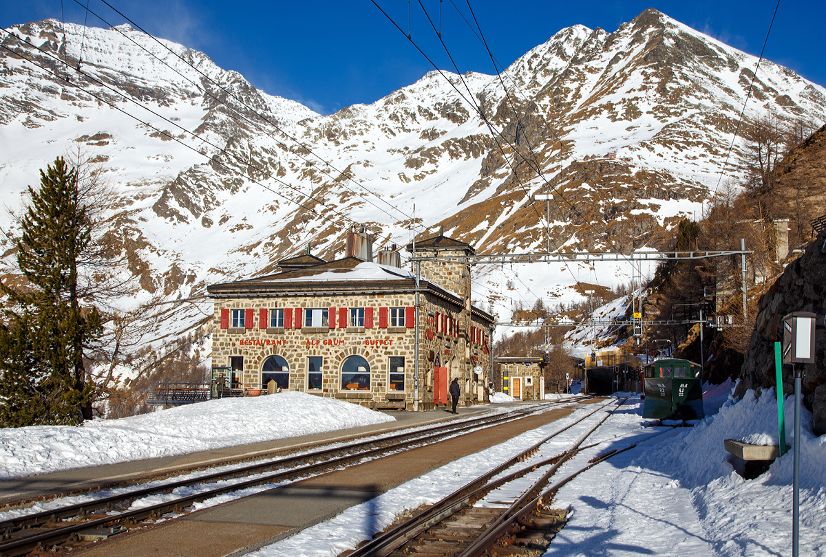 
Der Bahnhof Alp Grüm (2091 m ü. M) am 20.02.2017. Die Bahnstation Alp Grüm der Rhätischen Bahn (RhB) liegt an der Berninalinie von Pontresina nach Tirano. Sie befindet sich an der Südseite des Berninapasses und ist der letzte Bahnhof der Strecke im deutschen Sprachraum. Das heutige Bahnhofsgebäude, zugleich Buffet und Hotel, wurde 1926 eröffnet.

Die Strecke von Ospizio Bernina nach Poschiavo, an der der als Kreuzungsstation konzipierte Bahnhof liegt, wurde am 5. Juni 1910 von der Bernina-Bahngesellschaft eröffnet.

Vom Bahnhof hat man, vor allem dank der südlich der Station tiefer liegenden 180°-Kurve (Himmelskurve), einen weiten Ausblick auf den Palü-Gletscher, Lago Palü und ins Puschlav. Ab hier schlängeln sich die Züge der RhB in engen, teilweise überdachten Kurven und Kehren sowie durch fünf Kehrtunnel mit einem Gefälle von bis zu 70 ‰ hinunter ins Puschlav (italienischsprachige Schweiz).
