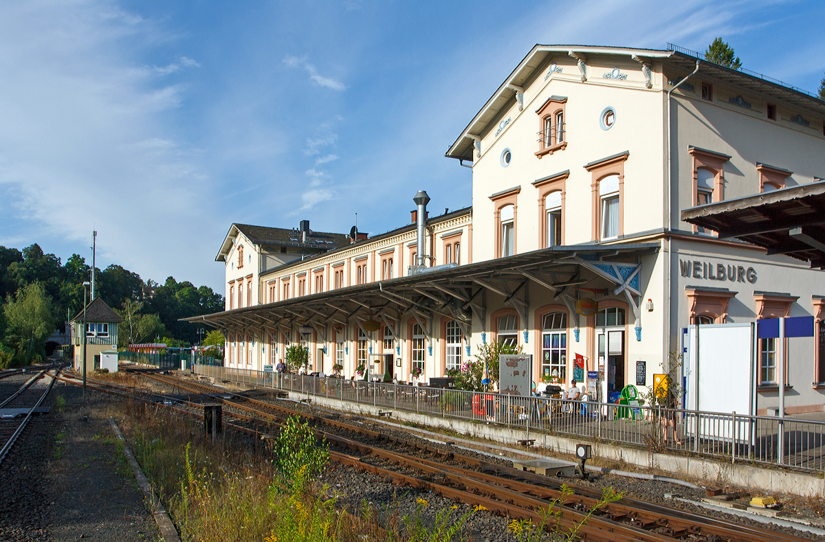 
Der Bahnhof Weilburg am 11.08.2014, Blick vom Bahnsteig. Ganz links im Bild das Nordportal von dem 302 m langem Weilburger Tunnel, etwas weiter rechts das Stellwerk Weilburg Fahrdienstleiter (Wf).

Der Bahnhof Weilburg ist ein Bahnhof in der mittelhessischen Stadt Weilburg. Der Bahnhof liegt an der Lahntalbahn. Von 1890 bis 1988 zweigte unmittelbar hinter dem Bahnhof die Weiltalbahn Richtung Weilmünster ab.

Erbaut wurde der Bahnhof Weilburg zunächst als Endbahnhof der Lahntalbahn im Zuge der Eröffnung der Teilstrecke zwischen den Bahnhöfen Limburg (Lahn) und Weilburg, welche am 14. Oktober 1862 in Betrieb genommen wurde.

Am 1. November 1891 wurde die Weiltalbahn von Weilburg bis Weilmünster eingeweiht. Nachdem die Fortsetzung bis Usingen am 1. Juni 1909 in Betrieb genommen war, konnten die Züge – zeitweise auch Eilzüge – von Weilburg bis Frankfurt am Main durchfahren. Weilburg wurde zum Verkehrsknotenpunkt und Umsteigebahnhof. Diese Verbindung endete, als am 27. September 1969 der Personenverkehr zwischen Weilmünster und Weilburg eingestellt wurde. Auf diesem Teilstück wurde noch bis zum 30. Januar 1988 Güterverkehr im Übergabeverfahren betrieben. Danach verlor der Bahnhof Weilburg seine Funktion als Knotenpunkt im Güterverkehr.

Vor dem Hessentag in Weilburg 2005 wurde der Mittelbahnsteig im Weilburger Bahnhof erneuert und behindertengerecht umgebaut. Der zusätzliche Behelfsbahnsteig zum Hessentag wurde anschließend wieder entfernt.

Das denkmalgeschützte Empfangsgebäude wurde als spätklassizistischer Bau von Heinrich Velde konzipiert und ähnelt den Bahnhofsgebäuden von Leun/Braunfels und Diez, die ebenfalls aus seinen Entwürfen entstammen. Zwischen giebelständigen, erhöhten Kopfbauten befindet sich ein traufständiger Trakt mit vorgelagerter Pultdachhalle, die nach der Zerstörung im Krieg vereinfacht wieder errichtet wurde. Die Gesimsbänder sowie die Giebel verfügen über Schmuckmotive. 

Heute befindet sich in dem Empfangsgebäude das Hotel-Restaurant Lahnbahnhof.
