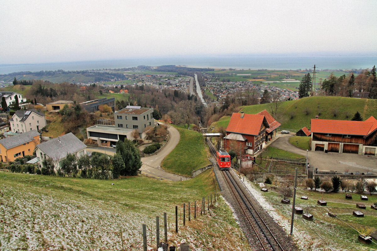 Der einzige Triebwagen BDe 1/2 der Rheineck-Walzenhausen Bahn unterhalb Walzenhausen. Von hier kann man praktisch auf die gesamte Strecke hinunterschauen, mit Rheineck in der Ferne. 27.Februar 2023 