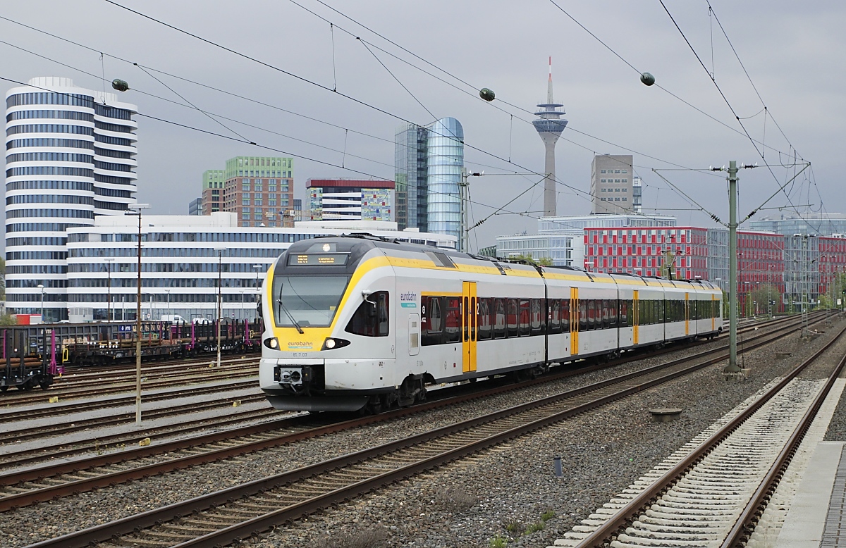 Der fünfteilige Eurobahn-Flirt ET 7.07 (Baureihe 0429) rollt am 29.04.2021 auf dem Weg von Hamm nach Venlo/NL durch Düsseldorf-Hamm, im Hintergrund die Hafen-City