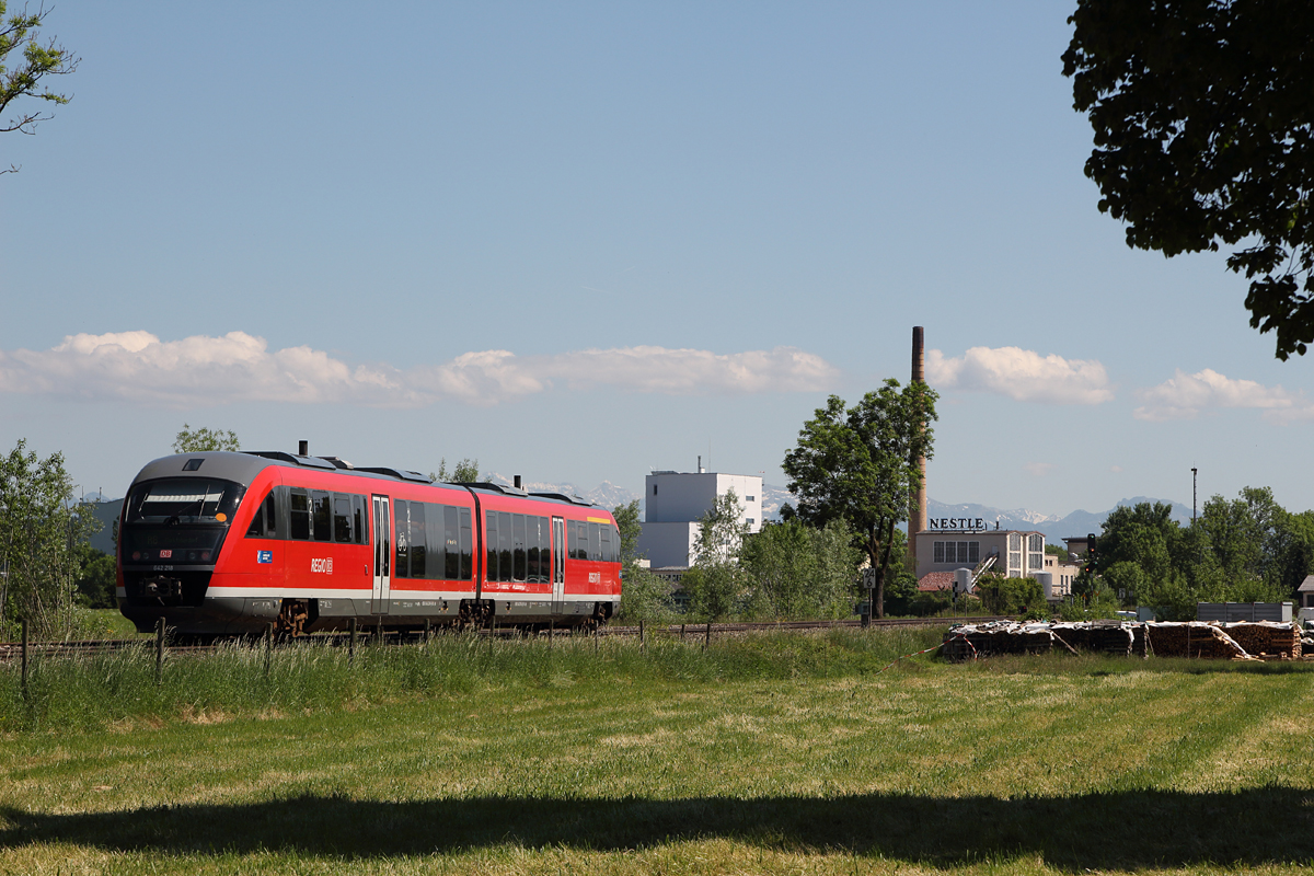 Der Kemptener 642 218-2 erreicht am 13.06.13 in Kürze Biessenhofen. Im Hintergrund die Alpen und ein Werk eines sehr bekannten Lebensmittelkonzerns.