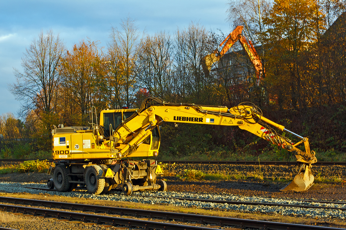 
Der Liebherr A 900 C ZW Li / 1031 Zweiwegebagger (Nr. 26), mit Vier-Punkt-Absttzung, der Hering Bau GmbH und Co. KG aus Burbach-Holzhausen beim planieren von Schotter auf den Rangierbahnhof der KSW Kreisbahn Siegen-Wittgenstein (ehem. Freien Grunder Eisenbahn AG) in Herdorf am 06.11.2014. 

Der Zweiwegebagger hat die Kleinwagen-Nr. 97 51 04 511 60-8), er hat ein Eigengewicht von 22,5 t, eine Anhngelast von 120 t und eine Hchstgeschwindigkeit von 20 km/h (in Weichen und Kreuzungen beschrnkt auf 10 km/h), er hat eine Kfz -Bremse und eine Waggonbremsanlage