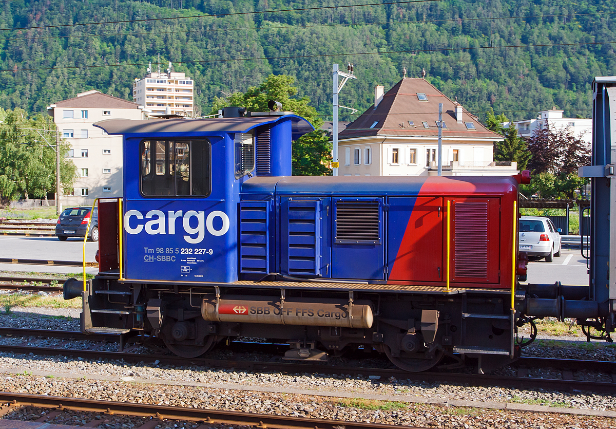 
Der Rangiertraktor (Rangierlok) Tm 232 227-9 (Tm 98 85 5 232 227-9 CH-SBBC) der SBB Cargo, ex SBB Tm IV -  9677, ist am 28.05.2012 beim Bahnhof Martigny abgestellt.

Die Lok wurde 1976 von der SLM unter der Fabriknummer 5084 gebaut und an die SBB, als Tm IV -  9677, geliefert. Ein Umbau, Remotorisierung (einschl. Partikelfiltern der neuesten Generation ohne Brenner) und Einbau einer Funkfernsteuerung erfolgte ca. im Jahr 2010 im SBB Industriewerk Biel, danach erfolgte die Umzeichnung in Tm 232 227-9. 

Als Tm IV werden bei der Schweizerischen Bundesbahnen (SBB) die 80 Rangiertraktoren mit Dieselantrieb bezeichnet, die zwischen 1970 und 1978 beschafft (und von der SLM gebaut) wurden. Der Index IV steht für die Leistungsklasse IV (über 350 PS).

Die Fahrzeuge wurden als fahrdrahtunabhängiges Fahrzeug für den Rangier- und Baudienst beschafft. Erstmals bei einer großen SBB-Fahrzeugserie, kam bei diesen Fahrzeugen die hydraulische Kraftübertragung zum Einsatz. Da das Turbowendegetriebe eine Ausrüstung für beide Fahrtrichtungen hatte, konnte auf das störungsanfällige mechanische Wendegetriebe verzichtet werden. Um die ungünstige Wirkungsgradcharakteristik abzuschwächen, wurde ein nur im Stillstand schaltbares Stufengetriebe eingebaut, das die Wahl zwischen einer Höchstgeschwindigkeit von 30 oder 60 km/h, oder die Wahl zwischen größerer Zugkraft oder größerer Geschwindigkeit ermöglicht.

Die Rangiertraktoren besitzen einen Außenrahmen mit obenliegenden Blattfedern, die sich auf die Achslager abstützen. Die Federn besitzen keinen Lastausgleich.

Die Kraftübertragung erfolgt von der Motorwelle über eine Kardanwelle (Gelenkwelle) zu einem zentralen Schaltgetriebe. Dieses ist als Voith-Turbogetriebe mit nachgeschaltetem Verteilgetriebe ausgeführt. Von dessen Antriebswelle (beidseitig)  weiter über zwei Gelenkwellen auf eine Achsgetriebe, das sich auf der jeweiligen Antriebachse befindet. Die beiden Achsen sind über die Gelenkwellen und Antriebswellen mechanisch verbunden.

Das Voith-Turbogetriebe ist ein vollautomatisch arbeitendes hydrodynamisches Strömungsgetriebe, das zwei Wandler besitzt. Als Betriebsflüssigkeit kommt Mineralöl zu Einsatz. Die beiden Wandler sind zueinander gegenläufig, wodurch die Fahrtrichtung geändert wird. Dem Turbogetriebe ist das Verteilgetriebe nachgeschaltet. Dort kann mechanisch die Übersetzung zwischen Rangier- und Streckengang geschaltet werden. Da es sich um ein nicht synchronisiertes Schaltgetriebe handelt, darf es nur im Stillstand geschaltet werden. Es besitzt auch eine Neutralstellung, in welchen der Schalthebel bei Schleppfahrt gebracht und verriegelt wird. Das Achsgetriebe besteht aus einem Kegelradgetriebe mit einem Übersetzungsverhältnis 1:3.357. Auf der der Kardanwelle abgewandten Seite ist das Gehäuse des Achsantriebes mit einer Drehmomentabstützung mit dem Fahrzeugrahmen verbunden.

Als Motor wurde ein schnelllaufender nicht aufgeladener 8-Zylinder Dieselmotor eingebaut. Die ersten Fahrzeuge waren mit einem MAN Motor des Typs R8V 16/18, mit 280 kW / 380 PS Leistung, ausgerüstet, dessen Produktion später von der MTU übernommen wurden. 

Umbau zu Tm 232
Neben der Neumotorisierung war der Einbau einer Zugsicherung der wichtigste Umbaupunkt, denn es werden doch heute vermehrt Streckenfahrten mit den Rangiertraktoren unternommen. Es kommt ein Caterpillar 6 Zylinder-Dieselmotor des Typs 13C Acert mit Ladeluftkühler und Partikelfilter zum Einbau. Die Motorleistung beträgt nun 310 kW, mehr lässt das hydraulische Getriebe auch nicht zu. Daneben wurde die Spannung der Steuerung von 36 Volt auf 24 Volt abgeändert. Neben dem Einbau einer neuen Sicherheitssteuerung und Zugsicherung werden auch alle Fahrzeuge mit einer modernen Funkfernsteuerung ausgerüstet. Die Umbauten wurden im Industriewerk Biel durchgeführt, das heute der SBB Division Personenverkehr zugeteilt ist.


TECHNISCHE DATEN (Tm 232, ex Tm IV)
Spurweite:  1.435 mm (Normalspur)
Achsformel: B
Länge über Puffer:  7.670 mm
Achsabstand:  3.570 mm
Treibraddurchmesser: 	 950 mm
Kleinster bef. Halbmesser: 	35m
Dienstgewicht: 	30 t
Höchstgeschwindigkeit: 30 (Rangiergang) / 60 km/h (Streckengang) / 90 km/h (geschleppt)
Traktionsleistung:  310 kW/421 PS (urspr. 280 kW / 380 PS)
Anfahrzugkraft: 90 kN
Dauerzugkraft:  60 kN
Motor (neu): 6 Zylinder Reihenmotor vom Typ Caterpillar 13C Acert)
Ursprünglicher Motor: 	8 Zylinder Reihenmotor vom Typ MAN Typs R8V 16/18
Leistungsübertragung:  Hydraulisch
Tankinhalt:  850 l (Diesel)
