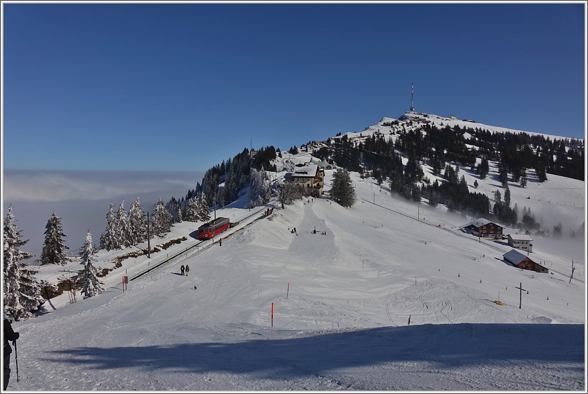 Der RB BDeh 2/4 2 schieb den Kkm 68 Richtung Rigi Kulm und erreicht in Kürze Rigi Staffel.
(24. Februar 2018)