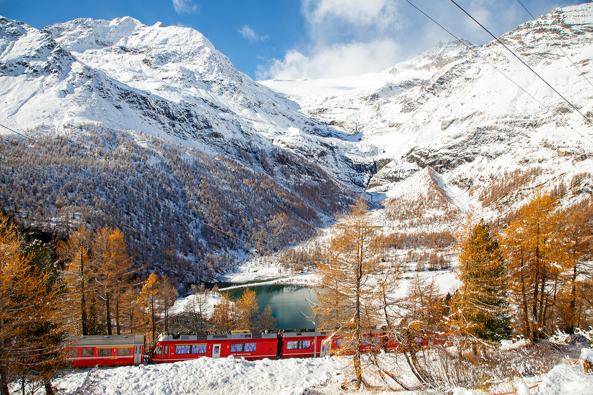 
Der RhB ALLEGRA-Zweispannungstriebzug (RhB  ABe 8/12) 3508  Richard Coray  mit 2 angehangenen Personenwagen als Regio-Zug nach Tirano fährt am 04.11.2019 von Alp Grüm nun hinab in Richtung Tirano. 

Unten der Lago Palü (Lagh da Palü, dt. Palüsee) am Fuße des Piz Palü. Der See wird größtenteils vom Palügletscher gespeist, den man (heute nur noch) oben in der Bildmitte erahnen kann.
