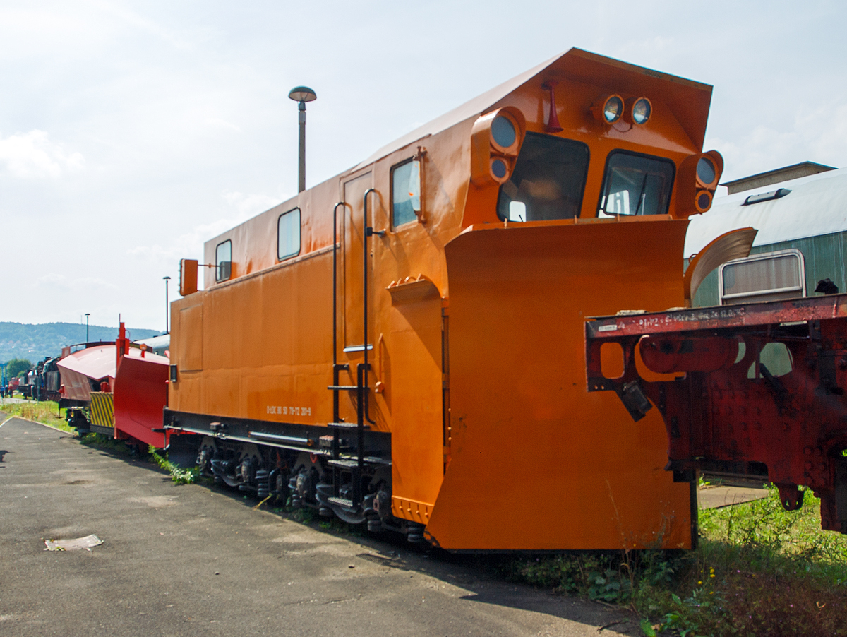 
Der Schneepflug 80 50 79-72 201-9 D-LDC von dem Lausitzer Dampflok Club e.V (Cottbus) ein Schneepflug der Bauart Meiningen 856, , am 24.08.2013 im Dampflokwerk Meiningen.

Hergestellt wurde er 1972 im RAW Halberstadt unter der Fabriknummer 6/2201.

Es gibt zwei Arten dieser Schneepflüge, zum einen die Bauart 855  Meinigen-W“ (Wechselsprechanlage)  oder wie hier die Bauart 856  Meinigen . Die Unterschiede ergeben sich aus den Fahrzeughöchstgeschwindigkeit Ba 855 hat eine Vmax von 100km/h bzw. Ba 856 eine Vmax von 50km/h, sowie der Übermittlung der Fahrbefehle.
Da die Ba 856 gegenüber der Ba 855 über keine Wechselsprechanlage verfügte, wurde dieselbe Übermittlung der Fahrbefehle bzw. Fahrgeschwindigkeiten gewählt, welche sich seit Jahrzehnten bei den  Klimaschneepflügen bewährt hatte.

Deshalb wurde der Schneepflug am Fahrzeugende mit einer Geschwindigkeitssignalisierungseinrichtung ausgerüstet, diese besteht aus acht Leuchtmeldern: 
Auf der linken Seite:
  Halt  rotes Licht
 Achtung  gelbes Licht
 Fahrt  grünes Licht

und auf der rechten Seite:
die Geschwindigkeitsanzeiger von oben nach unten:
 10  km/h 
 20  km/h 
 30  km/h 
 40  km/h 
 50  km/h
Das Bedienelement befindet sich im Führerraum des Schneepfluges und wird von dort aus bedient, dabei wird dasselbe Signalbild angezeigt, welche sich auch am Fahrzeugende (in Sichtweite des Lokführers) angezeigt wird.

Die ersten 50 Stück der Schneepflüge wurden vom Raw Halberstadt hergestellt und die zweite Lieferserie wurde mit 55 Stück im Raw Meinigen gefertigt. 


Der Meiningen-Pflug ist ein Ein-Richtungs-Schneepflug, ist also nicht auf dem Fahrgestell drehbar. Er verfügt über keinen eigenen Antrieb, sondern ist auf eine Schiebelokomotive angewiesen. Als Fahrgestell dienen Rahmen und Drehgestelle ausgemusterter Schlepptender des Typs 2'2'T32. Durch einen Betonballast wird das Gewicht des Schneepflugs auf 54 Tonnen gebracht.

Die Pflugschare sind nach dem von Rudolf Klima entwickelten Prinzip konstruiert, somit ist es auch ein Klima-Schneepflug, (senkrecht stehende Schare, in Grundstellung keilförmig zur zweiseitigen Räumung, ausschwenkbar zur einseitigen Räumung), mit Seitenräumflügeln. Zusätzlich ist ein keilförmiger Spurinnenräumer vorhanden .Die Bewegung der Pflugschare erfolgt über Druckluftzylinder. Die Druckluftanlage muss von der Lokomotive gespeist werden.

An den Führerstand des Schneepflugs schließt sich ein kleiner Aufenthaltsraum für das Personal an, dahinter folgt der Raum für das Stromaggregat. Die Besatzung des Schneepflugs besteht aus mindestens zwei Personen: Ein Schneepflugbediener und ein Arbeitszugführer. Bei drohender Gefahr kann vom Führerstand des Schneepflugs die Hauptluftleitung entlüftet werden und somit eine Bremsung des Gespanns eingeleitet werden. 

Technische Daten:
Länge über Alles: 11.500 mm
Eigengewicht: 54 t
Zur Mitfahrt zugel. Personen: 6
Höchstgeschwindigkeit: 50 km/h (zugelassen ohne SIFA)
