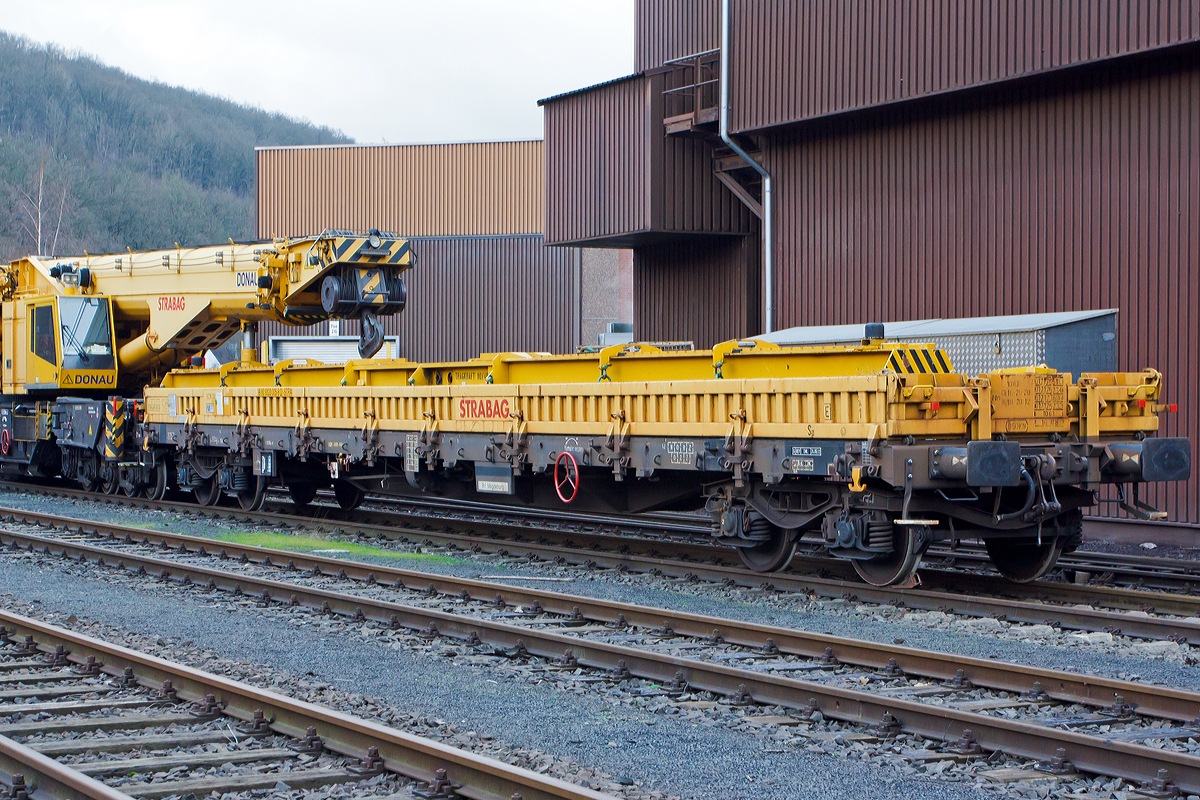 
Der Schutzwagen 99 80 9320 005-8 D-STRA der STRABAG RAIL GmbH, zum 150 t Kirow Gleis- und Weichenbaukran KRC 1200+ „DONAU“, abgestellt am 25.12.2014 am KSW Bahnhof Siegen-Eintracht (Betriebsbereich Eisern-Siegener Eisenbahn).

TECHNISCHE DATEN von dem Schutzwagen 99 80 9320 005-8 D-STRA:
Spurweite: 1.435 mm
Eigengewicht: 23.900 kg
Maximale Nutzlast: 56,1 t
Anzahl der Achsen: 4
Länge über Puffer: 19.900 mm
Länge der Ladefläche: 18.500 mm
Drehzapfenabstand: 15.000 mm
Achsabstand im Drehgestell: 1.800 mm
Bremse: OGP – DRV - 600
Höchstgeschwindigkeit: 100 km/h 
Zugelassen für Streckenklasse: CE oder höher
Kleinster befahrbarer Gleisbogen: R = 75m
Baujahr: 2009