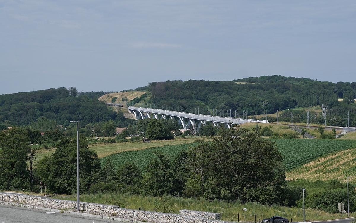 Der TGV 9881 von Luxembourg nach Montpellier hat den 816 Meter langen Savoureuse Viadukt hinter sich gelassen und fährt nun, kaum mehr zu sehen, weiter Richtung Dijon.

6. Juli 2019