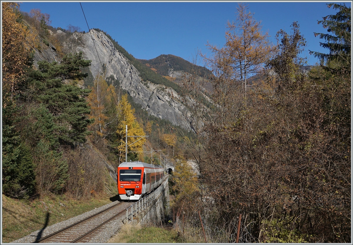 Der TMR RegionAlps RABe 525 041 (UIC 94 85 7525 041-0 CH-RA) ist von Sembracher nach Orsières unterwegs und fährt kurz nach Orsières durch einen bunten Herbstwald.

6. November 2020