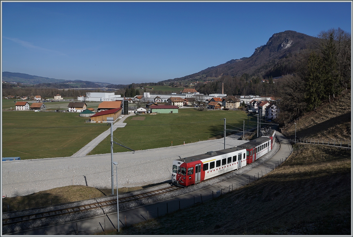 Der TPF Be 4/4 124 mit dem Bt 224 und dem ABt 223 sind als S60 14960 von Bulle auf dem Weg nach Broc-Fabrique und an dieser Stelle schon fast am Ziel der Reise. Die Schmalspurzüge werden bald durch Normalspurzüge aus Bern oder Fribourg abgelöst, im Bild sind schon Geländearbeiten für die Umspurarbeiten erkennbar. 

2. März 2021