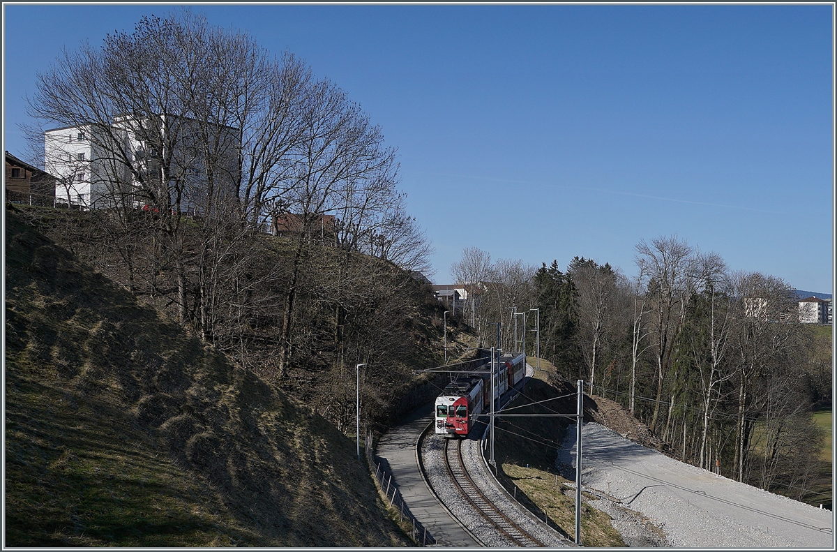 Der TPF Be 4/4 124 mit dem Bt 224 und dem ABt 223 sind als S60 14960 von Bulle auf dem Weg nach Broc-Fabrique und an dieser Stelle schon fast am Ziel der Reise. 
Die Schmalspurzüge werden bald durch Normalspurzüge aus Bern oder Fribourg abgelöst, rechts im Bild sind schon Geländearbeiten für die Umspurarbeiten erkennbar. 

2. März 2021