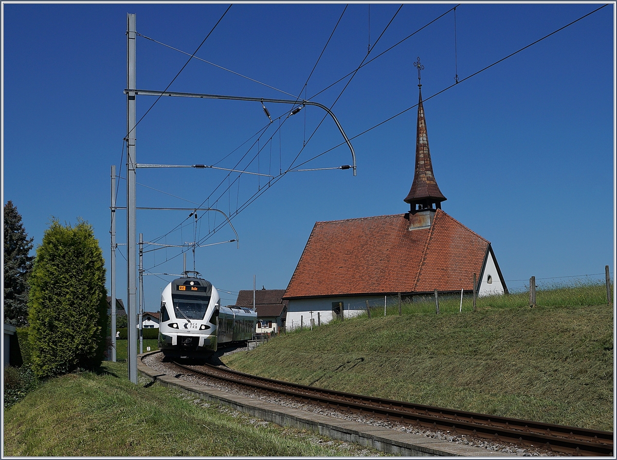 Der TPF RABe 527 198  BCF / FKB  (Kantonalbankwerbezug) erreicht Vaulruz, mit im Bild die  Kapelle von Vaulruz. 

19. Mai 2020