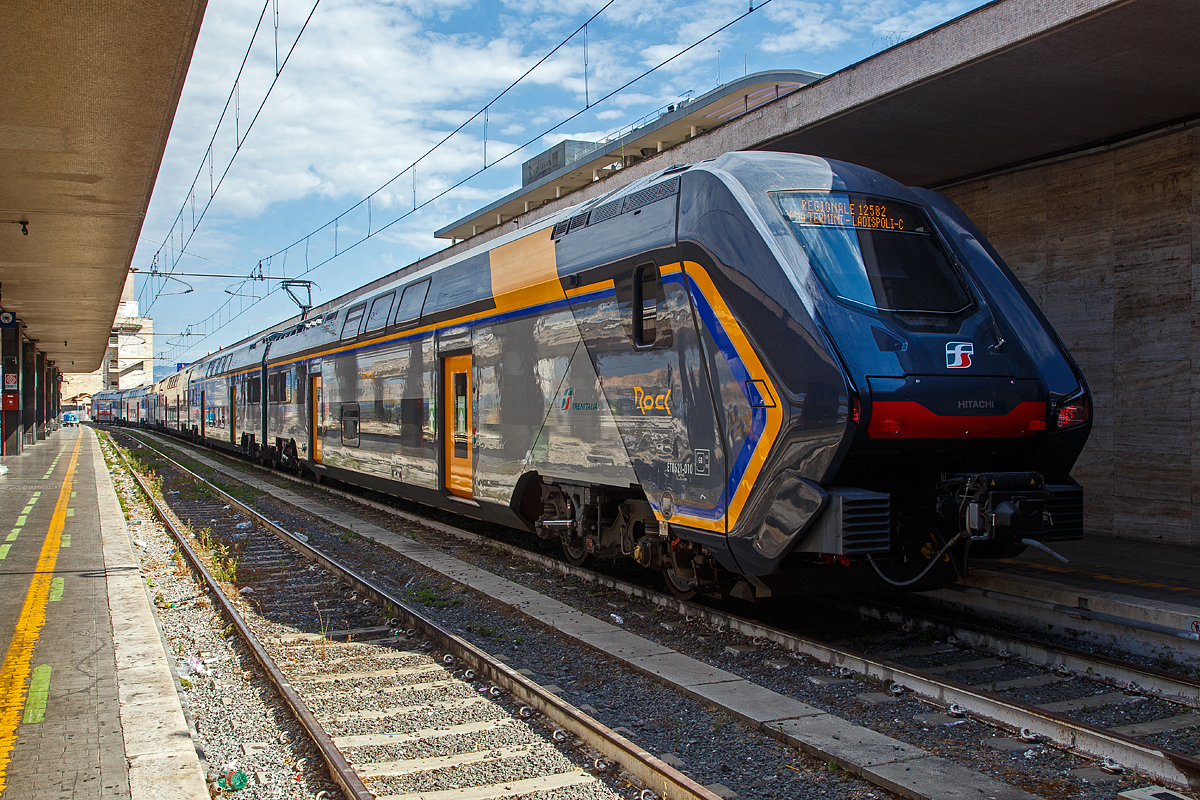 Der Trenitalia “Rock” ETR 621-010, ein sechsteiliger Elektrotriebzug vom Typ Hitachi Caravaggio, steht am 13.07.2022 im Bahnhof Roma Termini, als Regionale 12582 nach Ladispoli-Cerveteri (Küstenstadt nordwestlich von Rom), zur Abfahrt bereit.

Hitachi Rail Italien baut im Werk Pistoia diese doppelstöckigen Elektrotriebzüge (EMU) vom Typ Rock. Die Fahrzeuge werden als  ETR 421 (vierteilig) ETR 521 (fünfteilig) und ETR 621 (sechsteilig) bezeichnet. Diese sechsteilige Variante ist 163,4 m lang und bietet 729 Sitzplätze.
