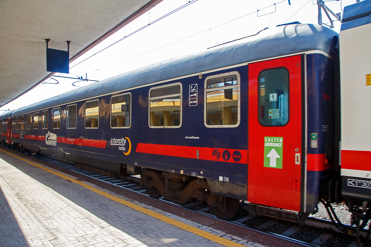 Der Trenitalia intercity notte Comfort Schlafwagen der Gattung Bc, eingereiht als Wagen 1 in den ICN 1959 von Roma Termini nach Syrakus (Siracusa), am 18.07.2022 im Bahnhof Catania Centrale. Diese Wagen haben bis zu 32 Schlafwagenpltze (am Tag Sitzpltze und in der Nacht Betten). 

TECHNISCHE DATEN: 
Spurweite: 1.435 mm
Lnge ber Puffer:  26.400 mm
Drehzapfenabstand: 19.000 mm
Sitzpltze: 32 (2. Klasse), bzw. bei Nacht Betten
Eigengewicht: 44 t
Hchstgeschwindigkeit:  160 km/h
Bremsbauart:  Freno WU-R 65t