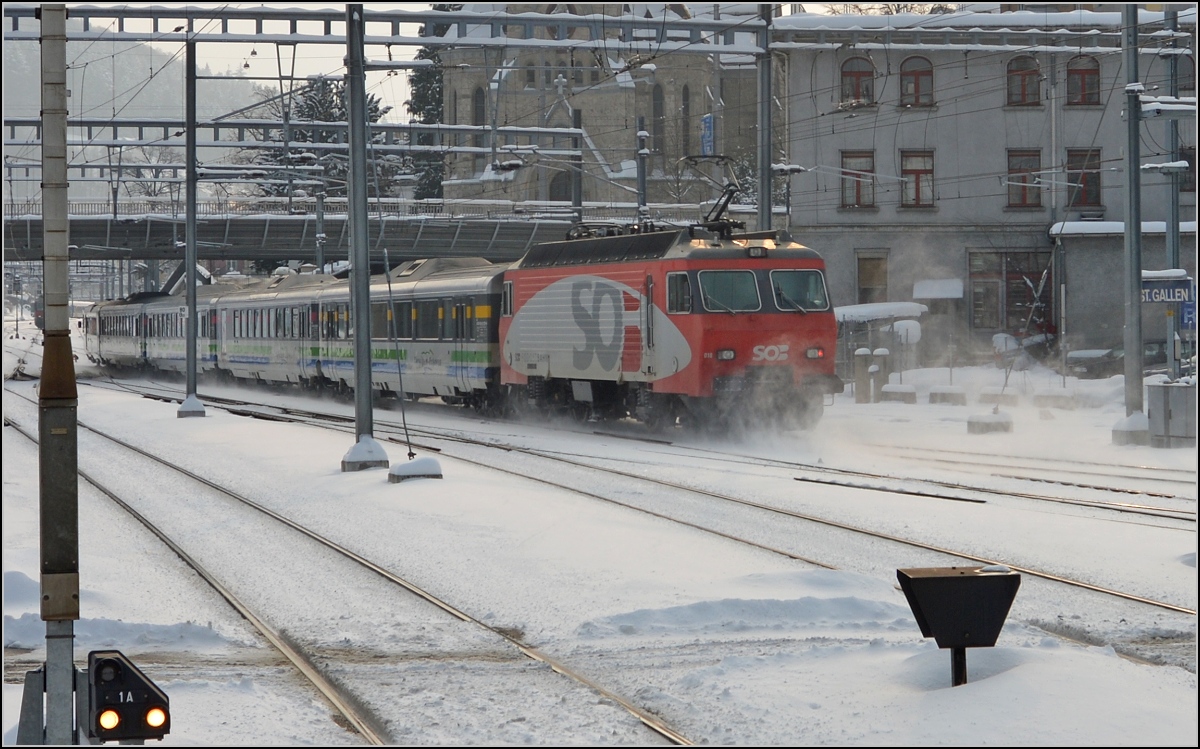 Der Voralpenexpress verlässt St.Gallen Richtung Herisau, es schiebt eine der vier Prototypen der Re 4/4 IV. In Serie wurden diese Loks nie gebaut. Februar 2013.