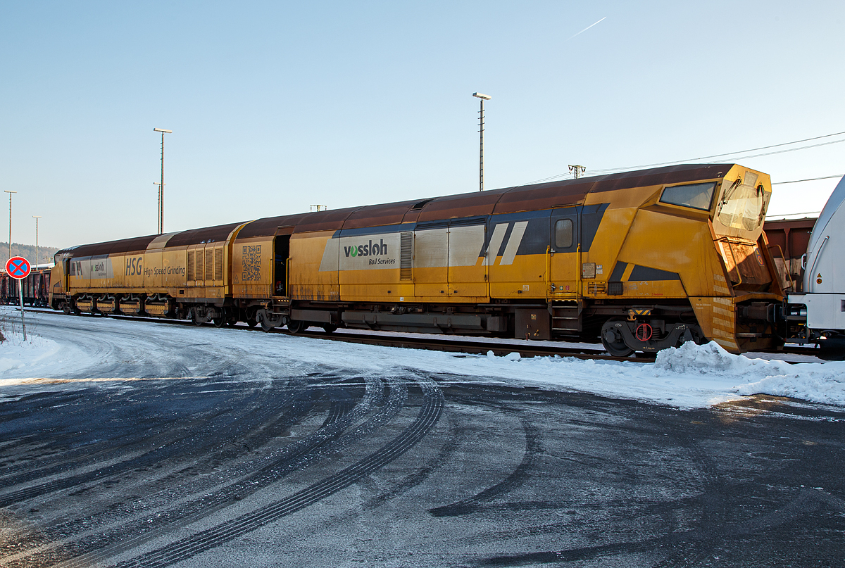 
Der Vossloh Hochgeschwindigkeitsschleifzug HSG - 2 (Vossloh High Speed Grinding), Schweres Nebenfahrzeug Nr. D-VMRS 9980 9527 002-6, der Vossloh Mobile Rail Services GmbH (Bützow), abgestellt am 22.01.2017 beim ICE-Bahnhof Montabaur.

Der Schleifzug wurde von Vossloh unter der Fabriknummer HSG-2-02 im Jahr 2012 gebaut. Die EBA-Nummer ist 10 C04A002.
   
Das Vossloh High Speed Grinding (HSG) ist eine innovatives und neuartiges Schienenschleifverfahren, dessen herausragendes Merkmal die weltweit einzigartige Arbeitsgeschwindigkeit von 80 km/h ist. Dadurch ist die Bearbeitung von Schienen ohne betriebsbehindernde Sperrpausen möglich. Hauptanwendungsbereich ist das präventive Schleifen zur Vermeidung von Rollkontaktschäden und Verriffelung.

TECHNISCHE DATEN:
Spurweite: 1.435 mm
Achsfolge:  unbek.
Anzahl der Achsen: 8 (in 4 Drehgestelle, vom Typ ELH RC25NT)
Länge über Puffer:  37.000 mm (18,50 m / 18,50 m)
Drehzapfenabstand: 2 x 14.600 mm
Achsabstand im Drehgestell: 1.800 mm 
Eigengewicht:  120.000 kg
Nutzlast: 32 t
max. Achslast: 23 t (Zul. Streckenklasse C2/CM2 und höher)
Höchstgeschwindigkeit: 120 km/h (Im Schleifbetrieb 80 km/h)
Motorleistung: unbek.
Laufkreisdurchmesser: 920 m
Kleister befahrbarer Gleisbogen: R 150 m
Zur Mitfahrt zugel. Personen: 5
Max. Anhängelast: - t
Tankinhalt: 3.600 l (Diesel)
Arbeitsrichtung: beidseitig
Anzahl der Schleifsteine: 96

Mit dem Hochgeschwindigkeitsschleifzug HSG-2 ermöglicht Vossloh den Netzbetreibern Schienenpflege im Fahrplan. Der gezielte Abtrag der aufgehärteten Schienenoberfläche mit High Speed Grinding beugt Head Checks oder Verriffelungen vor, und die stufenlose Anpassung der Schleifaggregate bietet eine Optimierung des Schienenquerprofils – bei bis zu 80 km/h Arbeitsgeschwindigkeit!  
Die Absaugtechnik fängt den Materialabtrag auf; die Staubbehälter fassen sechs Tonnen. Der Prozess wird exakt überwacht, und die Arbeitsergebnisse werden dokumentiert. Dank modularer Bauweise lassen sich zudem zwei Schleifzüge zu einer noch leistungsfähigeren twin-Version koppeln.

Prinzip:
High Speed Grinding basiert auf dem Prinzip des Umfangsschleifens, wobei alle Schleifkörper der Maschine passiv angetrieben (durch die Fahrbewegung) und hydraulisch zugestellt werden. Dieses patentierte Verfahren ermöglicht Arbeitsgeschwindigkeiten von bis zu 100 km/h. Der Abtrag von 0,1 mm wird routinemäßig durch drei Überfahrten (2x Schrupp-, 1x Schlichtmodus) sichergestellt.

Maschinenleistung:
Abtrag: ca. 50 µm pro Überfahrt, Rauhigkeit Ra < 8 µm
Arbeitsgeschwindigkeit: 60 bis 100 km/h (Normal 80 km/h)
Reichweite: ca. 100 km pro Schicht
Weichen werden ohne Einschränkung durchfahren, von der Bearbeitung aber ausgespart, Schaltmittel/Bahnübergänge müssen nicht ausgebaut werden.

Einsatzgebiete für das High Speed Grinding sind:
Präventivschleifen:  Vermeidung von Rollkontaktermüdungsschäden durch regelmäßiges Entfernen der ermüdeten Schienenoberfläche, dadurch dauerhaft gute Qualität des Fahrwegs. Der Arbeitsbetrieb erfolgt im Fahrplan. 

Walzhautschleifen: Zweck des Walzhaut- oder Erstlagenschliffs ist die Verzögerung von Riffelbildung sowie die Beseitigung bauseitig entstandener Schienenfehler. Hierbei werden 0,2 bis 0,3 mm von der Schienenoberfläche entfernt, welches in 5 bis 6 Überfahrten bei geringster Baubehinderung geschieht.

Akustikschleifen: Instandhaltung der Fahrflächenebenheit bedeutet, dies bedeutet Reduzierung des durchschnittlichen Schienenlärms durch regelmäßige Schienenpflege, zudem Minimierung von Verriffelungen und Schlupfwellen.

Schmierfilmbeseitigung: Herbstliche, durch Laub verursachte Schmierfilme auf der Schiene führen alljährlich zu erheblichen Betriebsproblemen. Auch andere Schmierfilme, beispielsweise durch Industrieansiedlungen an der Strecke und deren Luftverunreinigungen verursacht, können Probleme bei der Anfahrt oder beim Bremsen verursachen. Zudem kann die Signalgebung beeinträchtigt werden.

Quelle: Vossloh Rail Service GmbH und eigene Sichtung.
