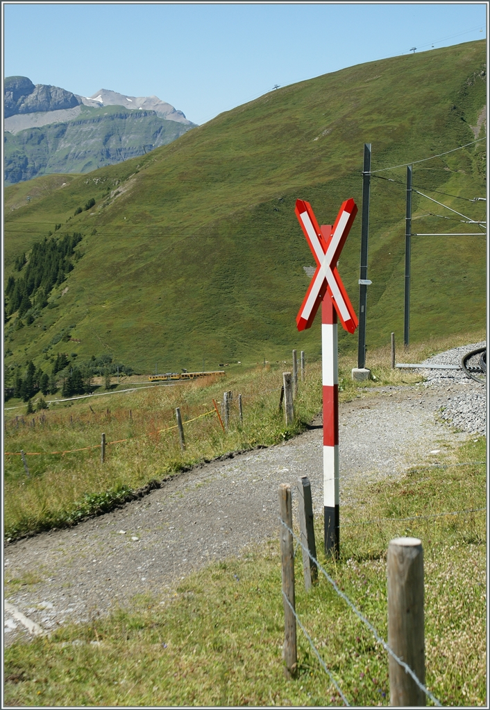 DEr WAB Zug, welcher ganz klein zu sehen ist, wird schon aus Gründen der  Spurweitweite nicht bei diesem sonnenbeschienn Anderaaskreus der JB vorbeifahren können. 
Oberhalb der Kleinen Scheidegg, den 21. Aug. 2013