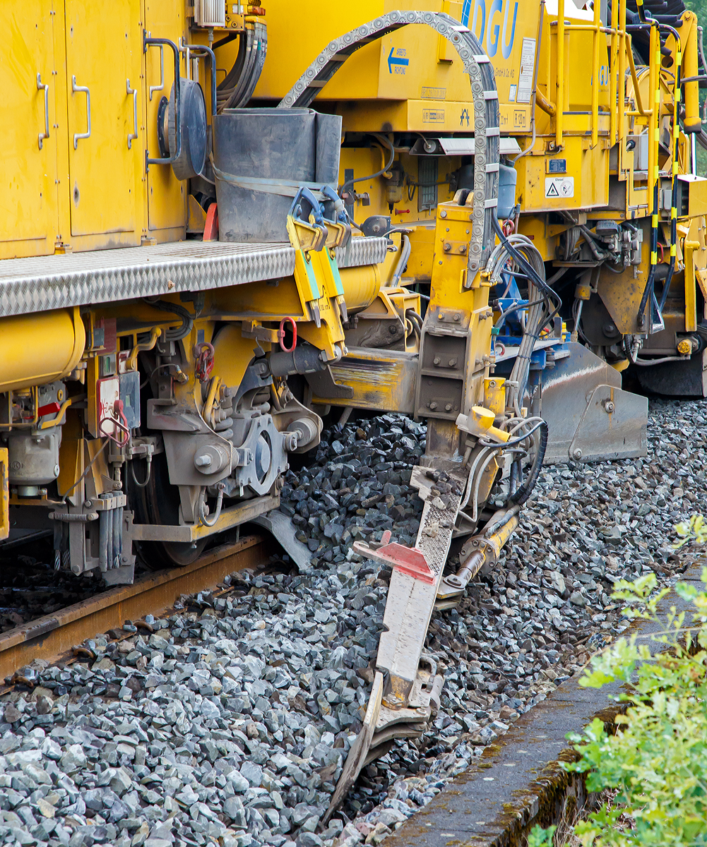 
DETAIL-Bild:
Die Plasser & Theurer Schnell-Schotterplaniermaschine SSP 110 SW,  Schweres Nebenfahrzeug Nr. D-DGU 99 80 9425 069-8 (ex 97 16 46 519 18-3), am 18.08.2019 auf der Dillstrecke (KBS 445) bei Wilnsdorf-Rudersdorf im Einsatz.
Der Schotter wird mit dem Seitenpflug planiert.
