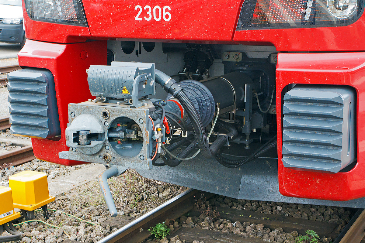 
Detail Scharfenbergkupplung (Schaku) Typ 10 mit obenliegender Elektrokontaktkupplung. Hier auch gut zu sehen die Anlenkung mit Stoßsicherung und der Zug- und Stoßeinrichtung. Hersteller der kompletten Einheit ist Voith Turbo Scharfenberg GmbH & Co. KG in Salzgitter
Hier an CFL 2306, ein dreiteiliger Elektrischer Doppelstocktriebzug Stadler KISS, am 14.09.2014 im Bahnhof Wasserbillig.
