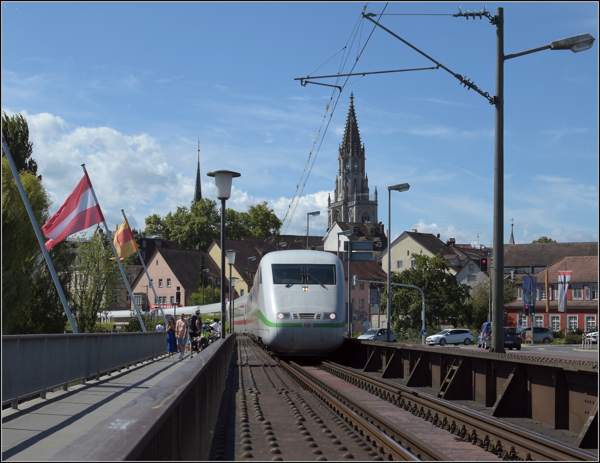 Deutschlands schnellster Klimaschützer zum Fahrgastinformationssystemtest auf Abwegen. Der vordere Triebkopf 401 055-7 vom ICE 1 Rosenheim auf der Rheinbrücke in Konstanz, schön vor der Kulisse des Münsters. August 2020.