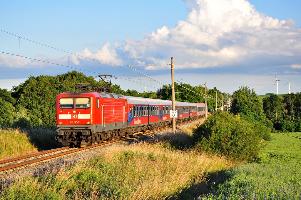 Die 112 155 rollt mit eine Kreuzfahrer am 25.06.2014 durch Gragetopshof in Richtung Rostock Hbf.