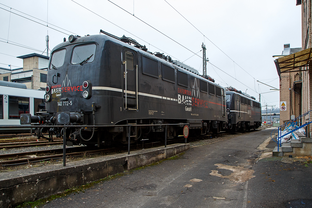 Die 140 772-5 (91 80 6140 772-5 D-EBS) und die 140 789-9 (91 80 6140 789-9 D-EBS) beide der EBS - Erfurter Bahnservice GmbH sind am 25.01.2022 vor der ehemaligen Lokleitung in Siegen beim Hbf Siegen abgestellt.

Lebensläufe der beiden E 40:
Vorne die 140 772-5 wurde 1970 von Henschel & Sohn in Kassel unter der Fabriknummer 31444 gebaut, der elektrische Teil ist von BBC (Brown, Boveri & Cie.) aus Mannheim. Als 140 772-5 wurde sie an Deutsche Bundesbahn geliefert. Im Jahr 1999 wechselte sie in den Geschäftsbereich DB Cargo AG und 2012 ging sie an die DB Tochter RBH Logistics GmbH in Gladbeck als RBH 161 (91 80 6140 772-5 D-RBH). 

Hinten die 140 789-9 wurde auch 1970, jedoch bei Krauss-Maffei AG ind München-Allach gebaut, der elektrische Teil ist von BBC (Brown, Boveri & Cie.) aus Mannheim. Als 140 789.9 wurde sie an Deutsche Bundesbahn geliefert. Auch sie ging 2012 an die DB Tochter RBH Logistics GmbH in Gladbeck als RBH 162 (91 80 6140 789-9 D-RBH). 

Beide Loks gingen 2016 an die EBS - Erfurter Bahnservice GmbH.

Die E 40 der Deutsche Bundesbahn und ab dem Jahr 1968 als Baureihe 140 geführten Loks sind technisch gesehen eine E 10.1 ohne elektrische Bremse, jedoch mit geänderter Übersetzung des Getriebes. Mit 879 Exemplaren ist die E 40 die meistgebaute Type des Einheitselektrolokprogramms der Deutschen Bundesbahn. Ihre zulässige Höchstgeschwindigkeit betrug am Anfang entsprechend ihrem vorgesehenen Einsatzgebiet im mittelschweren Güterzugdienst 100 km/h, diese wurde im Juni 1969 jedoch auf 110 km/h erhöht, um die Züge zu beschleunigen und die Loks auch besser im Personen-Berufsverkehr einsetzen zu können.

TECHNISCHE DATEN:
Spurweite: 1.435 mm
Achsanordnung: Bo´Bo´
Länge über Puffer: 16.440 mm
Drehzapfenabstand: 7.900 mm
Achsstand in den Drehgestellen: 3.400 mm
Gesamtachsstand: 11.300 mm
Treibrad-Durchmesser: 1.250 mm
Dienstgewicht:  86t
Achslast: 21,5t
Zulässige Höchstgeschwindigkeit: 110 Km/h
Stromsystem: Einphasen-Wechselstrom 15 000 V, 16 ²/³ Hz
Nennleistung: 3.700 kW (5.032 PS)
Zugkraft: 336 kN
Nennleistung Trafo: 4040 kVA
Anzahl Fahrstufen:  28
Anzahl Fahrmotoren:  4
Fahrmotor-Typ: SSW WB 372

Beschaffungskosten:  ca. 1.226.000 DM
