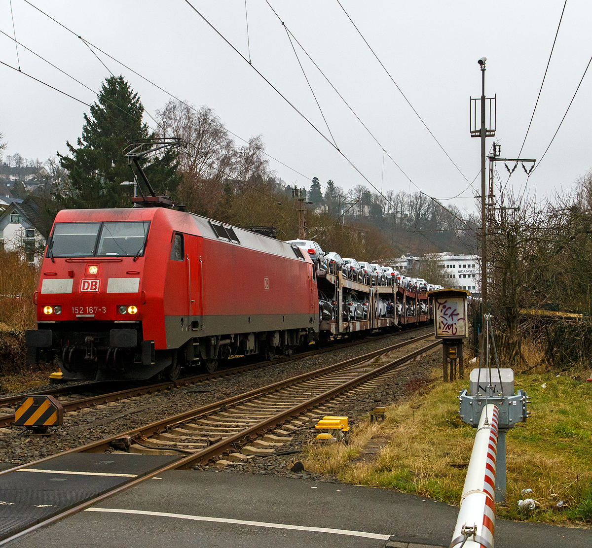 Die 152 167-3 (91 80 6152 167-3 D-DB) der DB Cargo AG kommt am 25.01.2022 mit einem Autotransportzug aus Richtung Gießen. Noch befährt der Zug hier in Siegen befährt sie gerade noch die Dillstrecke (KBS 445) bzw. die zweigleisige Strecke zwischen Siegen-Weidenau und Siegen Ost Gbf, bevor es ein paar Meter weiter auf die Ruhr-Sieg-Strecke (KBS 440) geht.

Ich stehe hier vor der Schranke am Bahnübergang.
