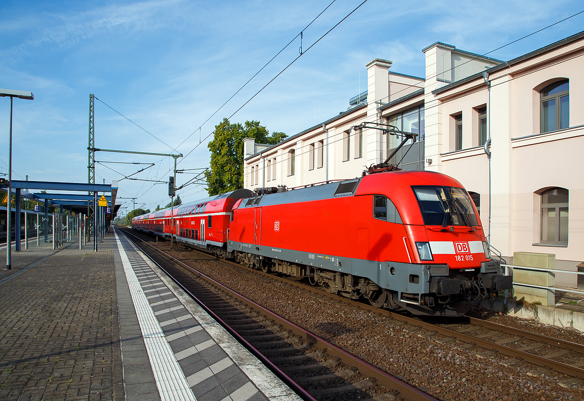 Die 182 015-8  (91 80 6 182 015-8 D-DB) der DB Regio (als Schublok) erreicht am 20.09.2018 mit dem RE 1 den Zielbahnhof Brandenburg an der Havel Hauptbahnhof.  

Die Lok wurde 2001 von Siemens in München-Allach unter der 20312 gebaut. 2011wurde bei Siemens in München-Allach ein Nahverkehrspaket eingebaut.

Die Hersteller-Bezeichnung ES64 ist die Abkürzung von EuroSprinter zusammen mit den ersten beiden Ziffern der Nennleistung (6.400 kW). Die Bezeichnung U steht für Universallok.

Die Lokomotiven der DB AG:
Die österreichischen Behörden verweigerten im Jahr 2001 die Zulassung der DB-Baureihe 152 in Österreich, weil man die auftretenden Gleiskräfte als zu hoch bewertete. Aus diesem Grund wandelte die Deutsche Bahn AG die Bestellung der letzten 25 Lokomotiven der DB-Baureihe 152 in 25 Maschinen der DB-Baureihe 182 um, die der ÖBB-Baureihe 1116 entspricht, allerdings wurde auf den bei der 1116 im Ursprungszustand üblichen dritten Stromabnehmer verzichtet, eine Nachrüstung wäre mit geringem Aufwand möglich.

Bei der Deutschen Bahn wurden die Lokomotiven daher seit der Übergabe der ersten Lokomotive im Juli 2001 wie die Baureihe 152 dem Geschäftsbereich DB Cargo zugeordnet. Damit wurde die Lokomotive mit der größten Höchstgeschwindigkeit (230 km/h) bei der Deutschen Bahn AG in einem Bereich eingesetzt, in dem diese nicht benötigt wird. Als Folge der Finanz- und Wirtschaftskrise gingen im Jahr 2009 die Transportmengen bei Railion (heute wieder DB Cargo) so stark zurück, dass die Güterverkehrssparte der Bahn einen Überhang an Lokomotiven hatte. Zudem hatten weitere Lokomotiven der DB-Baureihe 185 mittlerweile die Zulassung für Österreich erhalten, so dass der ursprüngliche Einsatzzweck auch anderweitig abgedeckt werden konnte. Im Herbst 2009 wurde daher ein Einsatz bei DB Regio in verschiedenen Regionen Deutschlands erwogen und teilweise auch erprobt.

Seit dem Fahrplanwechsel im Dezember 2009 fuhren fünf der Lokomotiven auf der Linie Cottbus–Leipzig. Auch auf der RB-Linie 20 in Thüringen kamen Lokomotiven diese Baureihe von 2010 bis 2015 zum Einsatz. Im Vergleich zu den dort bisher eingesetzten Lokomotiven der DB-Baureihe 143 wurde die Verspätungsanfälligkeit durch Geschwindigkeitsanhebung auf 140 km/h und die wesentlich schnellere Beschleunigung verringert.

Ab 2011 wurden acht Lokomotiven von DB Regio auf der Linie S1 der S-Bahn Dresden eingesetzt werden, um dort ebenfalls die Fahrzeiten zu verkürzen. Aber auch Einsätze als Ersatz für die Baureihe 442 auf dem RE50 Saxonia-Express auf der Relation Dresden – Leipzig waren die Regel. Ab Dezember 2015 wurden die acht Dresdner Lokomotiven (182 016 bis 023) an den Betriebshof Magdeburg-Buckau abgegeben, diese wurden durch die BR 146.0 ersetzt.

Die seit 2015 verkehren Loks der BR 182 mit fünf modernisierten Doppelstockwagen auf der Linie RE1 von Cottbus über Frankfurt (Oder), Berlin, Potsdam und Brandenburg (Havel) bis nach Magdeburg Hbf, entsprechend den Vorgaben des Bestellers (Verkehrsverbund Berlin-Brandenburg). Im August 2016 werden auch die bei DB Regio Südost in Magdeburg nicht mehr benötigten acht Maschinen der Region Nordost übergeben, sodass in diesem Regionalbereich bis auf weiteres alle Maschinen dieser Baureihe eine Heimat finden werden. 

Um sämtliche vorgenannte Talent-2-Ersatzverkehre abdecken zu können, sind im Laufe des Jahres 2011 alle 25 Maschinen der BR 182 in den Bestand der DB Regio übergegangen. Für die Dienste im Personenzugverkehr erhielten die Loks die Zulassung mit ep-Bremse und Notbremsüberbrückung (NBÜ 2004), was zum Erlöschen der Zulassung auf dem Netz der ÖBB-Infrastruktur AG führte – dem ursprünglichen Zweck ihrer Anschaffung. Alle 25 Lokomotiven wurden mit einem Nahverkehrspaket nachgerüstet, welches hauptsächlich aus seitenselektiver Türsteuerung (SAT/TAV) und Fahrgastinformationssystem besteht. 

Als 26. Lok der DB gehört die 182 506 seit 2013 der DB Systemtechnik und wird vor RAILab-Messzügen eingesetzt.

TCHNISCHE DATEN:
Achsfolge:  Bo`Bo`
Spurweite:  1.435 mm
Länge über Puffer:  19.280 mm
Drehzapfenabstand: 9.900 mm
Breite: 3.000 mm
Raddurchmesser (neu):  1.150 mm
Gewicht: 86 t
Spannungssysteme:  15 kV, 16,7 Hz und 25 kV, 50 Hz
Dauerleistung:  6.400 kW
Höchstgeschwindigkeit:  230 km/h
