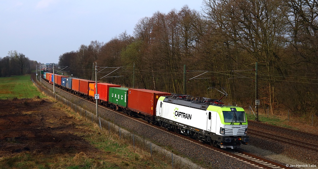 Die 193 894-3 von Captrain fuhr am 01.04.17 bei Radbruch mit einem Containerzug durch ein Waldstück.