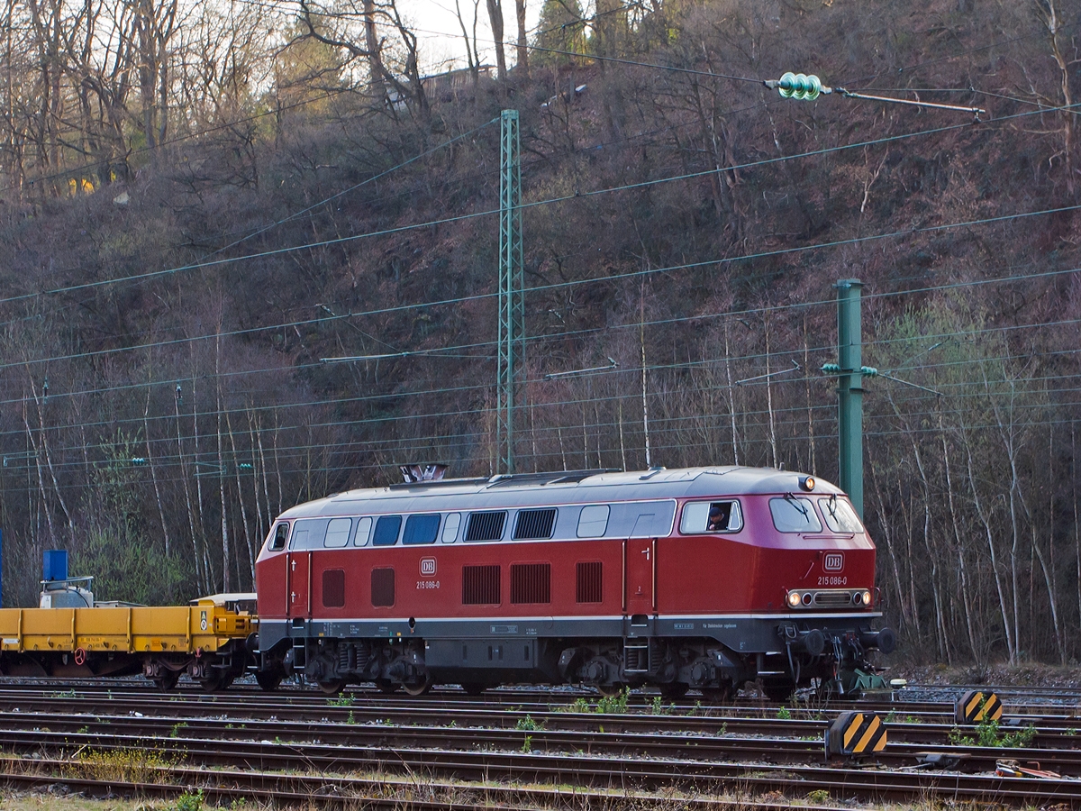 Die 215 086-0 (eigentlich 225 086-8) der RE - Rheinische Eisenbahn am 27.03.2014 rangiert einen Bauzug in Betzdorf/Sieg.

Die V 163 wurde 1971 bei MaK unter der Fabriknummer 2000091 und an die DB ausgeliefert, 2001 ging sie an die DB Cargo AG und wurde in 225 086-8 umbezeichnet, ob sie die Dampfheizung behaten hat kann ich nicht genau sagen. Mit der Ausmusterung bei der nunmehrigen DB Schenker Rail Deutschland AG im Jahr 2011 erfolgte auch der Verkauf an die RE - Rheinische Eisenbahn, hier wurde sie wieder in den Auslieferzustand zurckversetzt und trgt nun wieder die Bezeichnung 215 086-0 ist aber weiter einer 225er (NVR-Nummer 92 80 1225 086-8 D-EVG).

Die Lokomotiven der Baureihe 215 wurden kurzfristig als Variante der V160-Familie fr den Personen- und Gterverkehr beschafft und dabei im Gegensatz zu anderen Baumustern der V160-Familie mit Heizdampferzeugern ausgerstet. Geplant war sie im alten Baureihenschema als V 163. Diese Lokomotiven sollten spter in die Baureihe 218 umgebaut werden knnen. Dazu erhielt sie bereits den um 400 Millimeter verlngerten Lokkasten anderer bis dahin nur als Prototyp vorhandener Baureihen. Der Hauptgrund fr den Bau der Baureihe 215 lag darin, dass die Reihe 218 noch nicht Serienreife erreicht hatte, die Bundesbahn aber die restlichen noch vorhandenen Dampflokomotiven ersetzen wollte. 1968 bis 1970 wurden insgesamt 150 Lokomotiven gebaut.

Mitte der 1980er erhielten die Maschinen mit 12-Zylinder-V-Motor Abgashutzen auf dem Dach (wie diese). Sie bewirkten eine Beschleunigung und Umlenkung der Abgase, so dass bei klimatisierten Reisezugwagen, welche auf dem Dach die Luftansaugffnungen hatten, eine Belstigung der Fahrgste durch Abgase oder Abgasgerche vermieden wurde. Weiterhin sorgten die Hutzen noch fr andere Effekte: die bis zu 280 C heien Abgase wurden V-frmig an der Oberleitung vorbeigeleitet, so dass die Oberleitung nicht verrut wurde und sich nicht zu sehr ausdehnte. Auerdem wurde die Gefahr von Bschungsbrnden durch herabsinkende, heie Rupartikel reduziert. Auch eine Trschlieanlage und Bremsgestngesteller zum automatischen Nachstellen des Bremskolbenhubes wurden nachgerstet.

Technische Daten:
Achsformel:  B'B'
Spurweite:  1.435 mm
Lnge:  16.400 mm
Drehzapfenabstand:  8.600 mm
Drehgestellachsstand:  2.800 m
Gesamtradstand: 11.400 mm
Gewicht: 79 Tonnen
Radsatzfahrmasse:  20,0 Tonnen
Hchstgeschwindigkeit: 140 km/h (90 km/h im Rangiergang) Motorentyp: MTU MA 12 V 956 TB 10 (ein V12-Zylinder-Diesel-Motor), 
Dauerleistung: 1.840 kW (2.500 PS)
Nenndrehzahl: 1500 min-1
Leistungsbertragung: hydraulisch, ber Kardanwellen vom mittig angeordneten Getriebe zu den beiden zweiachsigen Drehgestellen. So werden ber Radsatzgetriebe jeweils beide und somit alle Achsen angetrieben. Ein Wendegetriebe ermglicht den Richtungswechsel.
Getriebe: Voith L 820 brs  
Tankinhalte: 3.050 l (Kraftstoff) / 2.850 l (Wasser) / 690 l (Heizl) / 320 kg Sand
Zugheizung:  Dampf