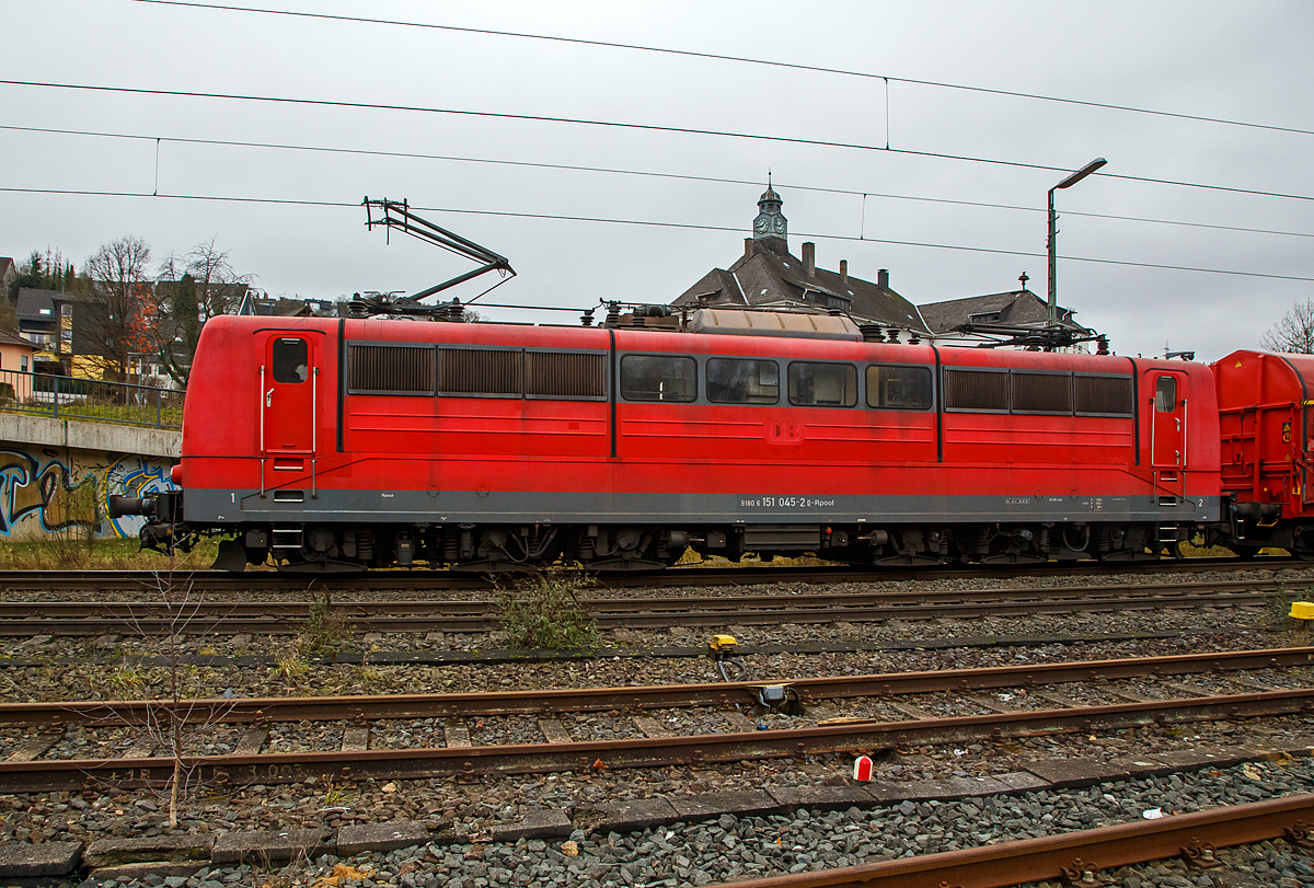 Die an die DB Cargo AG vermietete Railpool 151 045-2 (91 80 6151 045-2 D-Rpool) fährt am 04.12.2021 mit einem Coilzug durch Niederschelden in Richtung Köln.

Die Lok wurde 1974 von der Krauss-Maffei AG in München-Allach unter der Fabriknummer 19664 gebaut und an die Deutsche Bundesbahn geliefert. Bis 31.12.2016 gehörte sie zur DB Cargo AG. Zum 01.01.2017 wurden je 100 sechsachsige elektrische Altbau-Lokomotiven der Baureihen 151 und 155 an ein Konsortium aus dem Lokvermieter Railpool verkauft. Die DB Cargo mietet daraufhin 100 Loks von Railpool wieder an. Die anderen Maschinen werden dem freien Markt angeboten. Den Sinn dahinter kann man nicht ganz verstehen.
