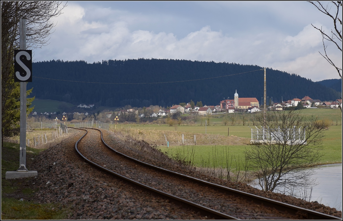 Die Bahnstrecke Besançon–Le Locle (-La-Chaux-de-Fonds) wird auch Ligne des Horlogers genannt, weil in den Höhenlagen des Jura das Uhrmacherhandwerk zu Hause ist. Hier die Strecke entlang des Doubs bei Grand Combe-Chateleu. Im Hintergrund ist Montlebon zu sehen. April 2018.