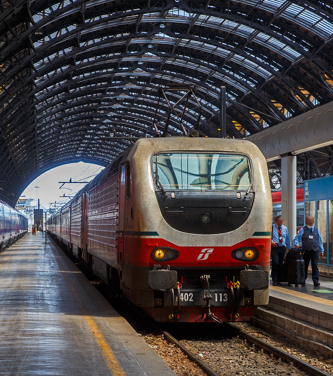 Die beiden E.402B 113 und 111 (91 83 2402 113-x I-TI und 91 83 2402 111-5 I-TI) erreichen am 12.07.2022, mit einem Trenitalia InterCity Notte (ICN), den Bahnhof Milano Centrale (Mailand Hbf).

Die FS E.402B ist eine Weiterentwicklung der E.402A, verfügt jedoch gegenüber ihrem Vorgängermodell zum Beispiel über ein höheres Gewicht sowie einen neu gestalteten und futuristischeren Wagenkasten. Die Höchstgeschwindigkeit ist jedoch mit 200 km/h etwas geringer als bei der E.402A (mit 220 km/h). Von den Loks wurden 80 Stück zwischen 1997 und 2000 von Ansaldo, Firema Trasporti (Fiore-Casertane), ITIN und SOFER gebaut.

Die Baureihe E.402B ist eine Mehrstromlokomotive, sie kann unter 3.000 V Gleichstromspannung, dem hauptsächlichen italienischen Bahnnetz, aber auch auf den italienischen Schnellfahrstrecken mit 25 kV, 50 Hz Wechselstrom fahren. Fernerhin kann sie unter 1.500 V Gleichstrom betrieben werden, dann hat sie aber nur die halbe Leistung. 

Die Lok ist eine vollelektronische Chopperlokomotive, das heißt, wenn die Lokomotiven unter 3.000 V DC fährt, wird der Strom mit Hilfe eines Zerhackers in Wechselstrom umändern, der dann schließlich die Motoren antreibt. 

TECHNISCHE DATEN:
Spurweite:  1435 mm (Normalspur)
Achsformel: Bo'Bo'
Länge: 19.420 mm
Drehzapfenabstand: 10.450 mm
Achsabstand im Drehgestell: 2.850 mm
Treibraddurchmesser:  1.250 mm
Dienstgewicht: 89 t
Höchstgeschwindigkeit: 200 km/h
Stundenleistung: 6.000 kW
Dauerleistung: 5.600 kW
Anfahrzugkraft: 280 kN
Stromsysteme: 3000 V DC, 25 kV - 50 Hz AC und 1500 V DC (bei halber Leistung)