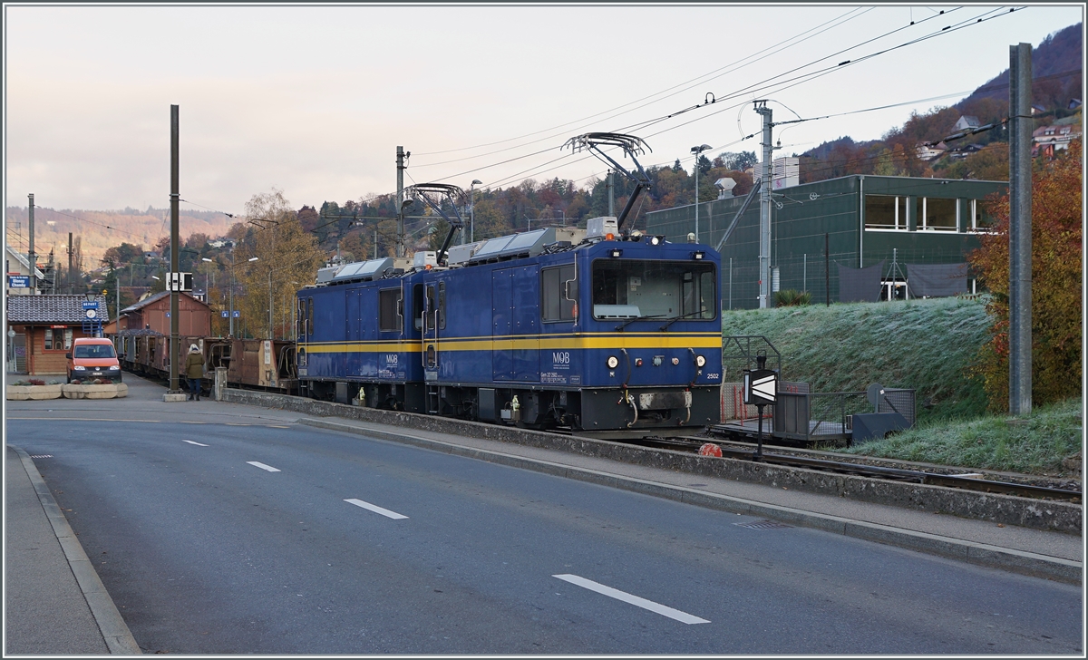 Die beiden MOB Gem 2/2 2502  und 2504 warten mit einem leeren Schotterwagenzug in Blonay auf die Abfahrt nach Chamby. Die im Bild zu sehenden vollen Kieswagen bleiben in Blonay.

9. November 2021