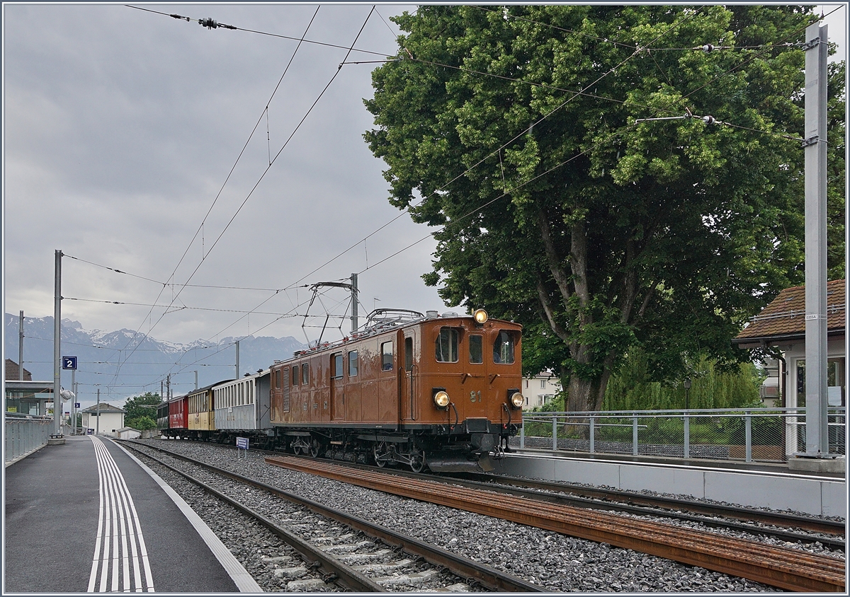 Die Blonay Chamby Bernina Bahn Ge 4/4 81 bei der Rückfahrt nach Blonay mit ihrem  Riviera Belle Epoque  fährt in St-Légier Gare durch. Trotz grundlegendem Umbau der Station St-Légier Gare steht das Ensemble des schönen grossen Baums sowie des kleinen Stationsgebäude weiterhin an ihren Platz.

9. Juni 2019