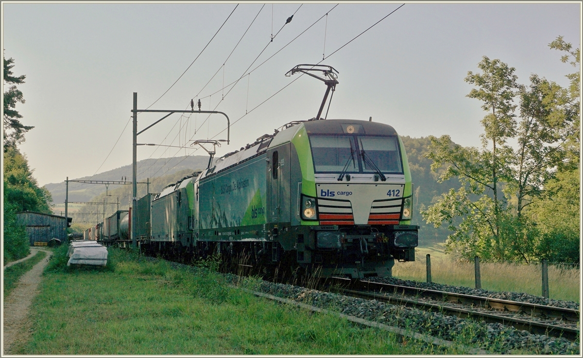 Die BLS Re 475 412 und eine weitere fahren im Schatten mit einem via Alte Hauensteinlinie umgeleiteten Güterzug Richtung Sissach. Der Zug fährt gerade durch den Bahnhof Sommerau und wird in Kürze eine Stelle erreichen die sich  Gotthard  nennt. 18. Juli 2018