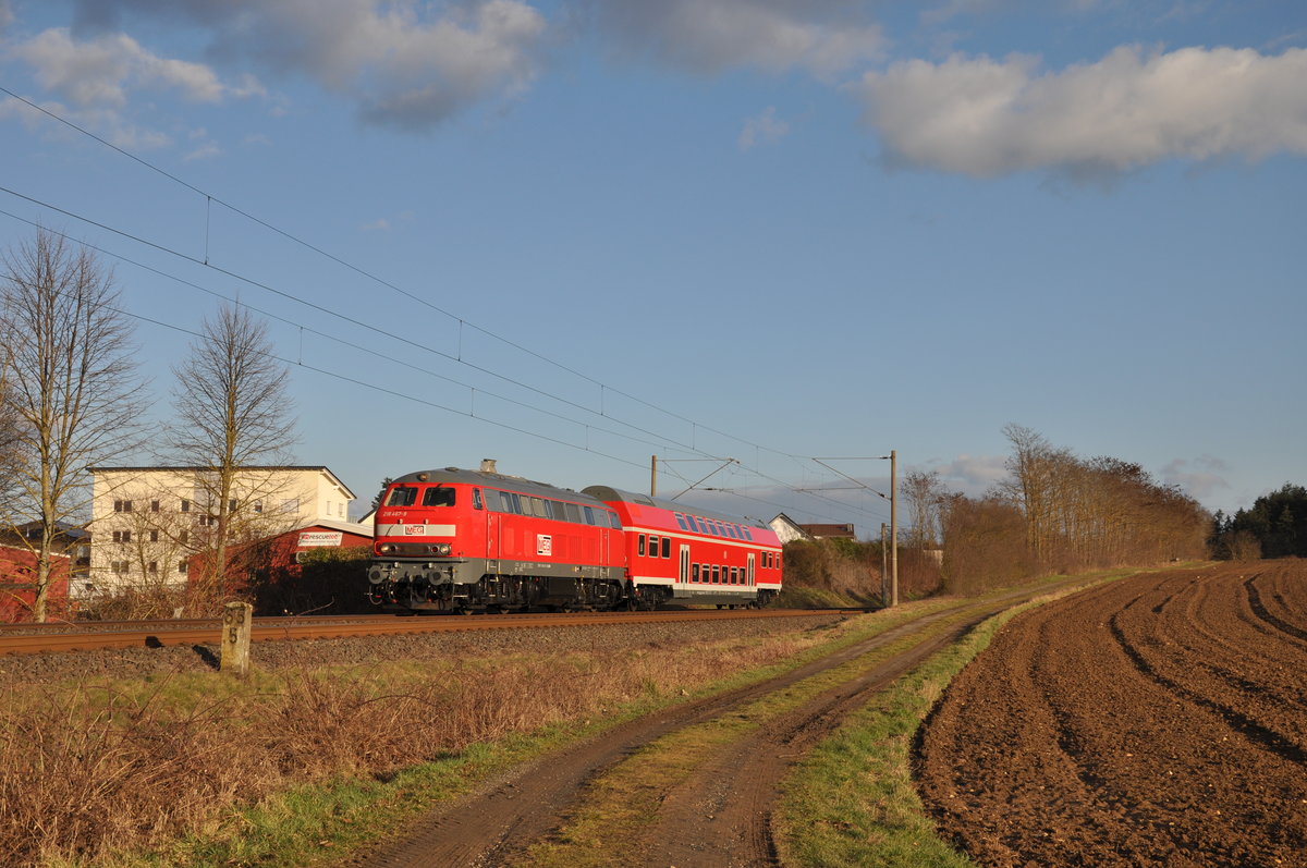 Die Bundespolizeischule in Diez bekommt für Übungszwecke einen alten Doppelstockwagen der Deutschen Bahn. Hierbei handelt es sich um den Wagen 50 80 25 - 33 042 - 6 (DBuza 747.4). 
Am 05. März 2021 hatte daher 218 467-9 die Aufgabe, jenen Doppelstockwagen von Apolda nach Diez zu befördern, wo der Wagen dann vier Tage später von einem Schwertransport abgeholt wurde und es zu einem  künstlich angelegten  Bahnhof in der Bundespolizeischule ging. 
Aufgenommen wurde das Bild bei Ennerich, ungefähr 10 Sekunden nachdem sich die Wolken von der Sonne verzogen haben und mir glücklicherweise ein Bild mit Sonne geling.  